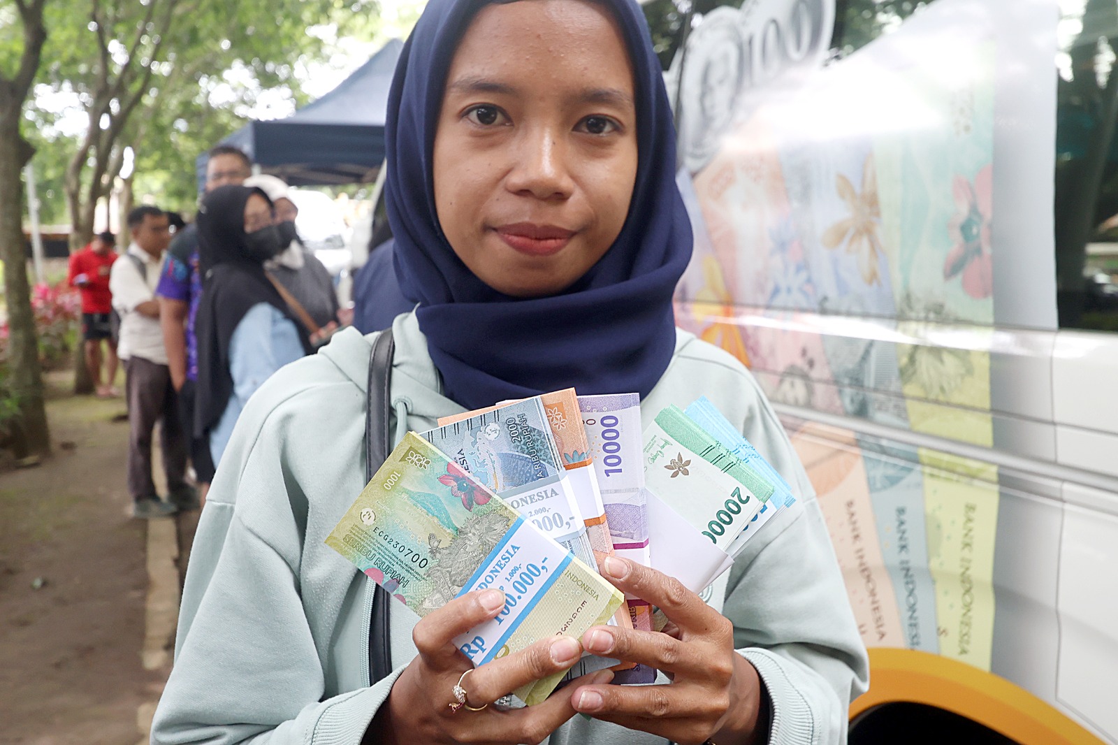 ANTUSIASME: Salah satu warga menunjukkan uang baru pecahan Rp  1.000 sampai Rp 20.000 hasil penukaran di Taman Singha Merjosari.