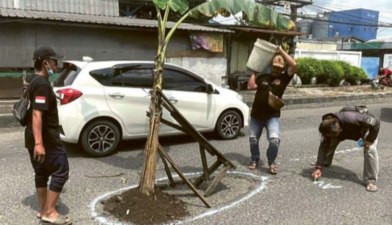 BUTUH PERBAIKAN: Warga Desa Sadang menanam pohon pisang di tengah Jalan Raya Sadang&ndash;Kletek, Kecamatan Taman, Sidoarjo, kemarin (20/2).