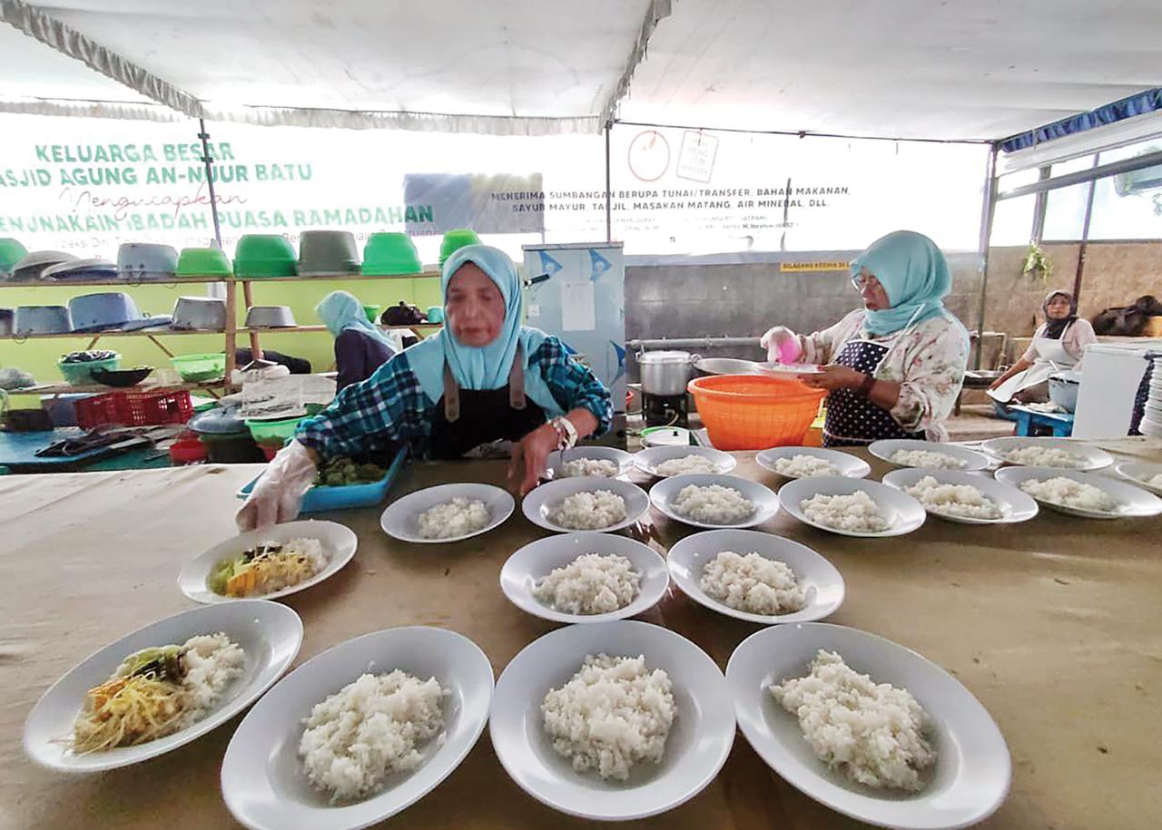 BERI RASA NYAMAN: Pengurus Masjid An-Nur Kota Batu menyiapkan hidangan berbuka puasa bagi jamaah kemarin sore. (Rori Dinanda Bestari/Radar Malang)