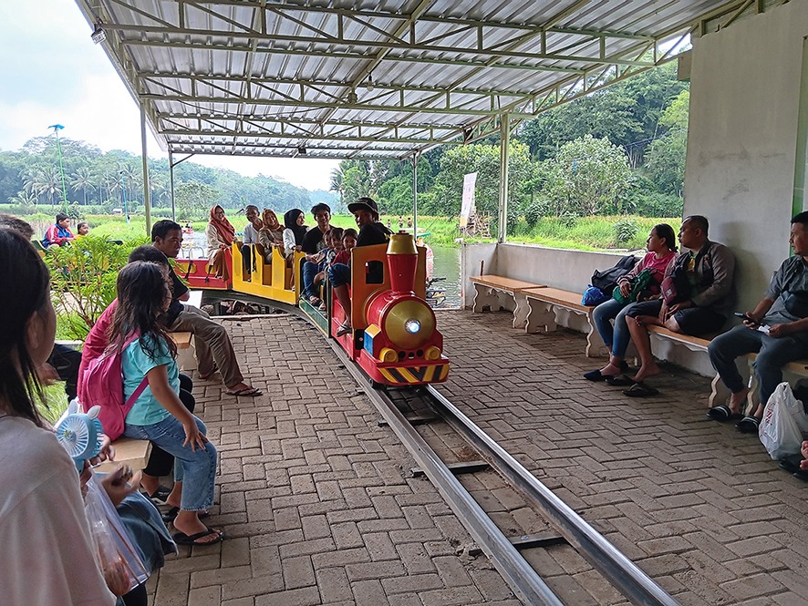 SUMBANG PAJAK: Pengunjung Sumber Sira yang didominasi anak-anak antre naik kereta mini kemarin siang.