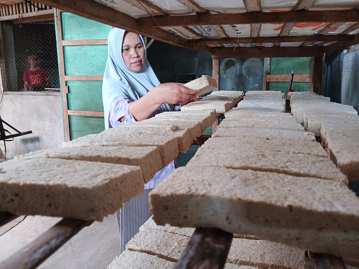 HARUS PUTAR OTAK: Produsen tempe di Kepanjen menata hasil olahannya sebelum dipasarkan kemarin siang. Di tengah fluktuasi harga kedelai, perajin memilih berbagai siasat agar usaha tetap bertahan.