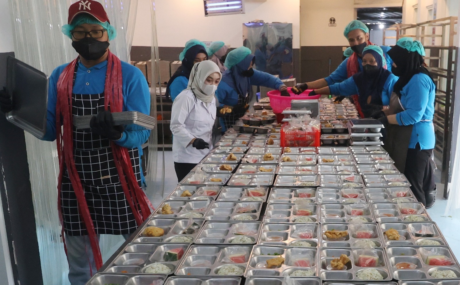 HARUS JADI ATENSI: Para pegawai di SPPG Trunojoyo, Kota Malang sedang mempersiapkan Makan Bergizi Gratis (MBG), beberapa waktu lalu. 