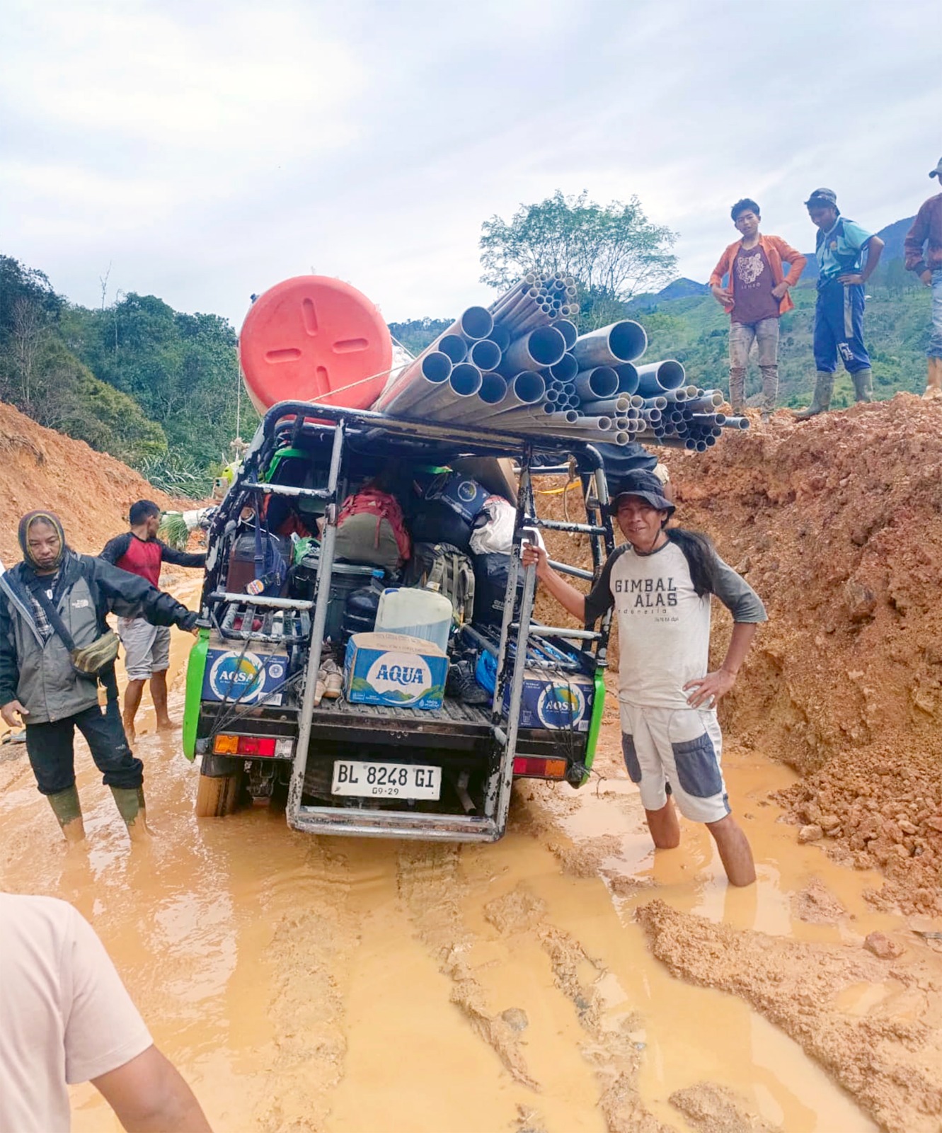 MISI TERPAKSA BATAL: Trianto Hermanda (kanan bawah) bersama relawan Gimbal Alas dan masyarakat lokal berusaha mendorong mobil yang terjebak di jalur menuju Desa. (TRIANKO HERMANDA FOR RADAR MALANG) 