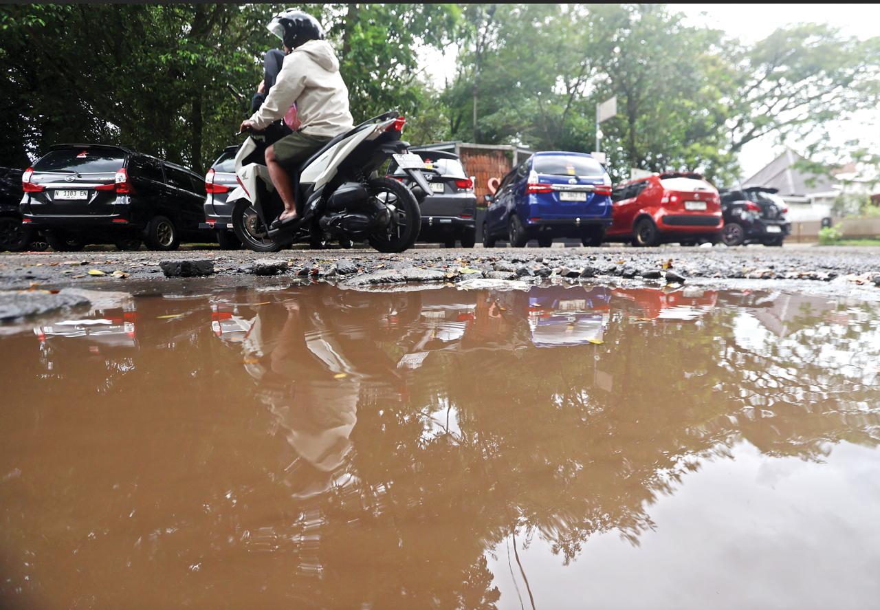 MEMBAHAYAKAN: Jalan rusak di Taman Slamet menjadi kubangan ketika diguyur hujan kemarin (25/2). DPUPRPKP menerjunkan tim khusus perbaikan jalan.