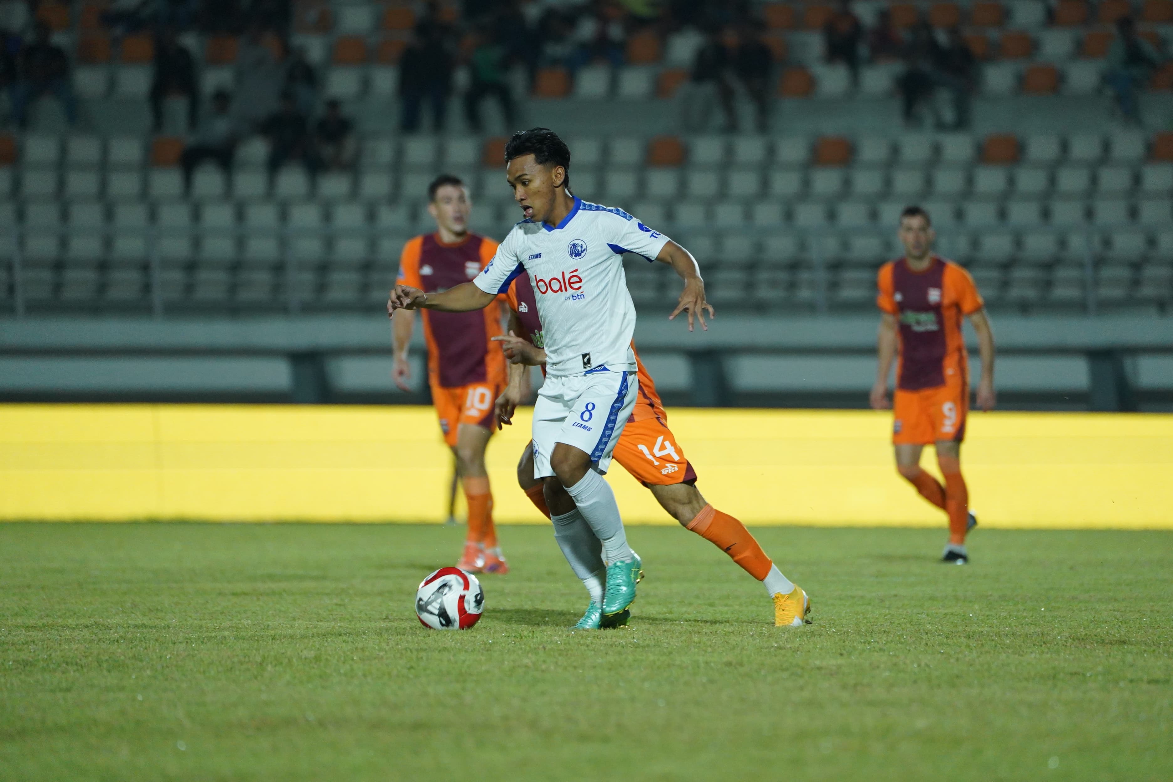 Gelandang Arema FC Arkhan Fikri menggiring bola menjauhi pemain Borneo FC dalam lanjutan BRI Super League pekan ke-23 di Stadion Segiri, Samarinda, Kamis (26/2) malam. (MO Arema FC)