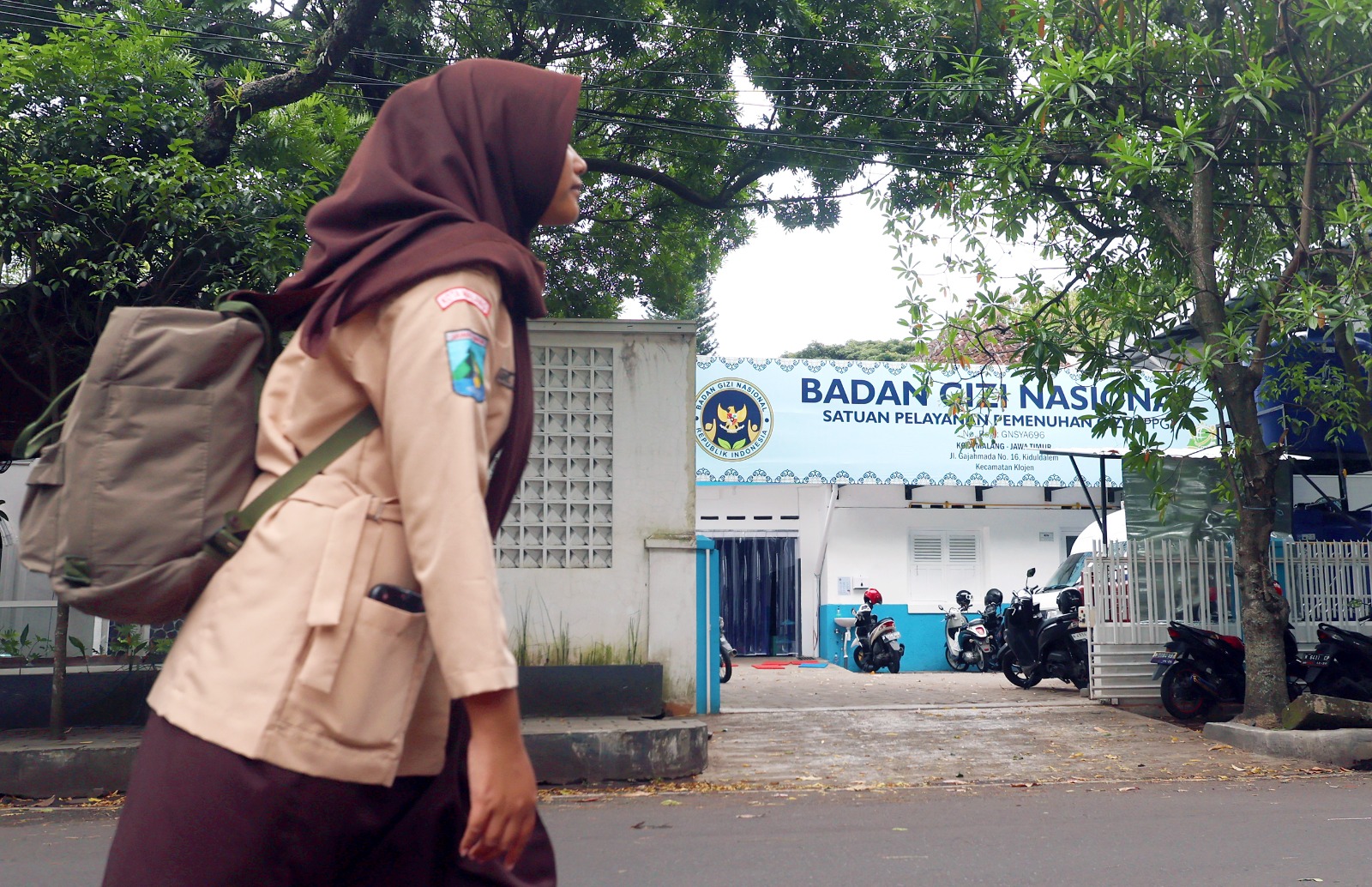 MENU BERGIZI: Pelajar putri melintas di depan SPPG Jalan Gajah Mada kemarin (26/2). Belum semua dapur MBG mengantongi Sertifikat Laik Higiene dan Sanitasi (SLHS).