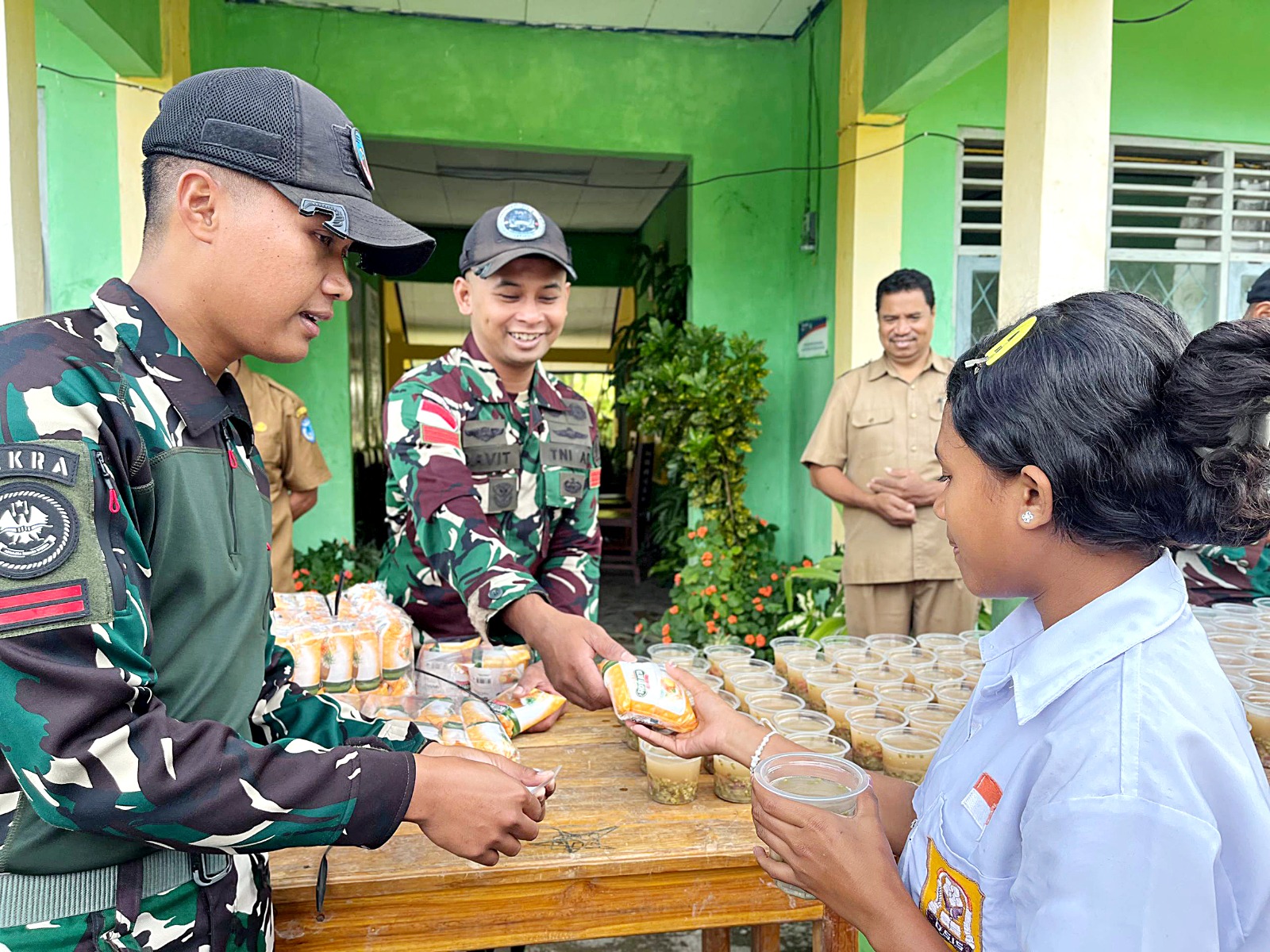 MENGABDI: Personel Yonarhanud 2 Kostrad membagikan bubur kacang hijau di Desa Eban, Kabupaten Timor Tengah Utara (TTU), Nusa Tenggara Timur yang berbatasan langsung dengan Timor Leste.