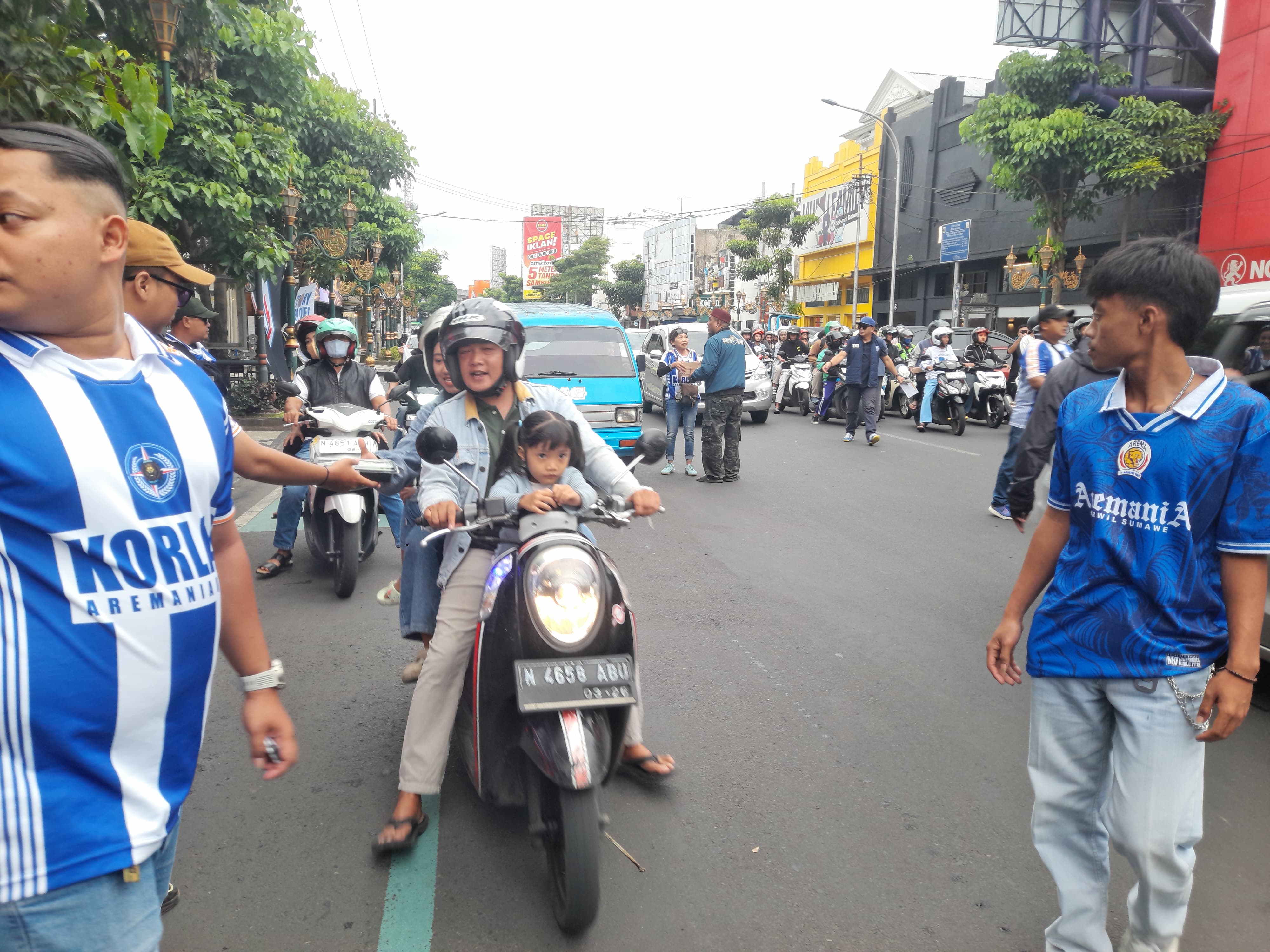 Aremania Utas membagikan takjil gratis ke pengendara yang melintas di Kajoetangan Heritage, Minggu (1/3). (MA Fauzan)