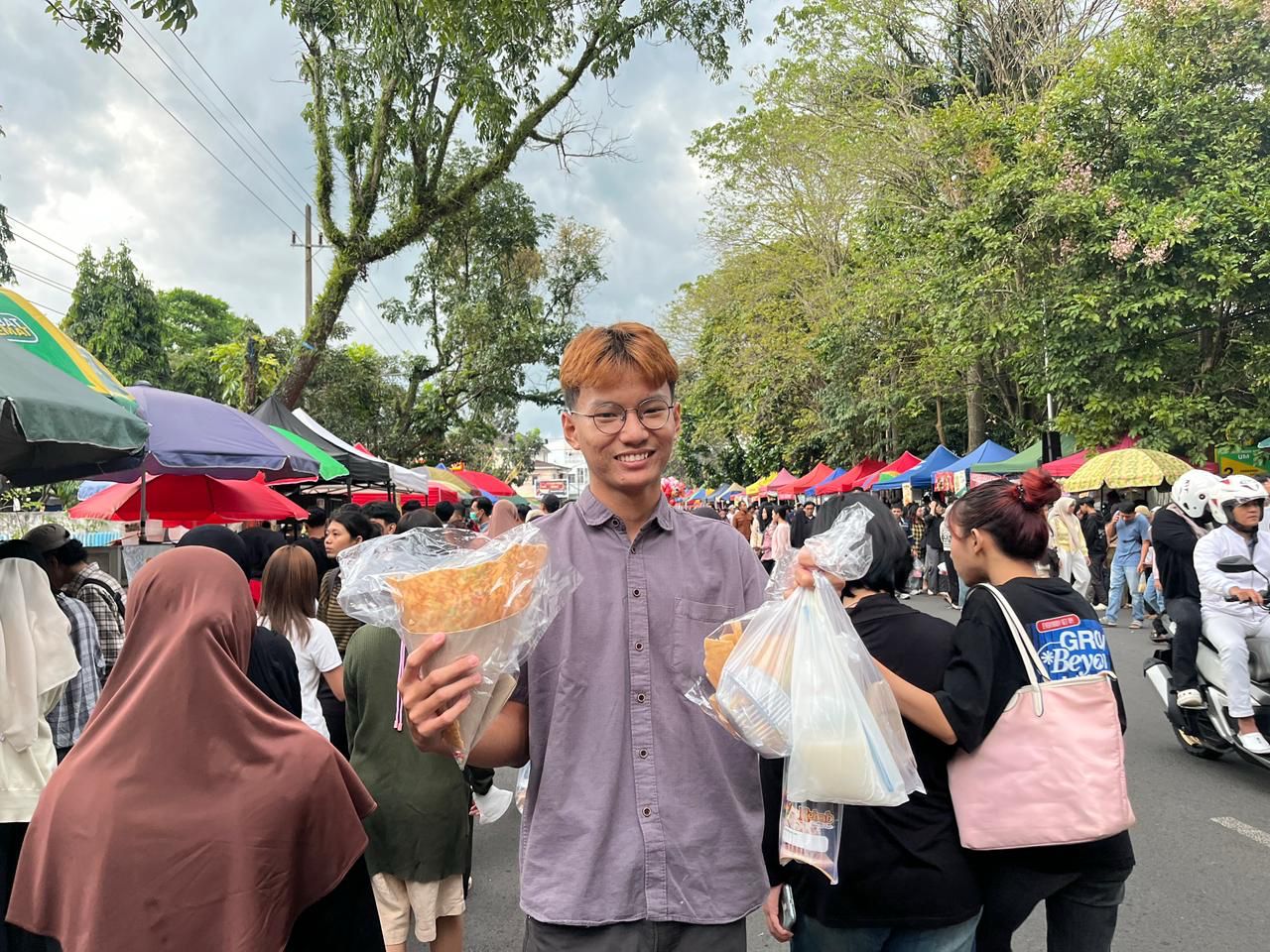 BORONG SAMPAI HABIS: Seorang mahasiswa membeli jajanan dan menghabiskan uang hingga Rp 100 ribu di pasar takjil Jalan Surabaya pada Kamis (26/2) lalu. (NAHDIATUL AFFANDIYAH/RADAR MALANG)