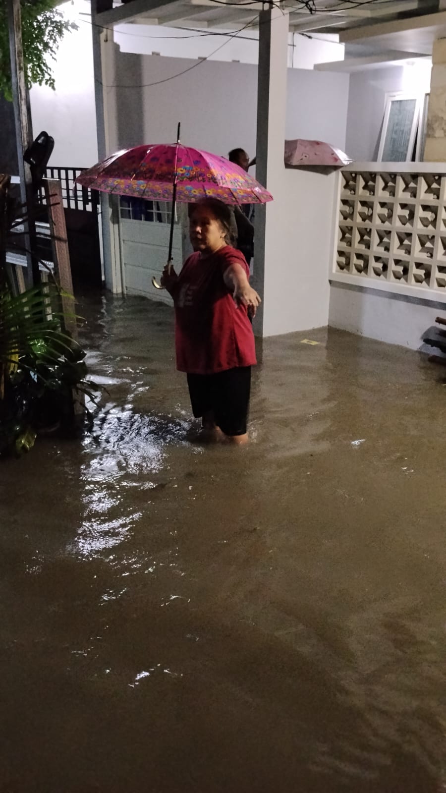 Warga Mangliawan, Kecamatan Pakis menunjukkan ketinggian banjir setelah diguyur hujan deras pada Sabtu (28/2). (BPBD Kabupaten Malang)