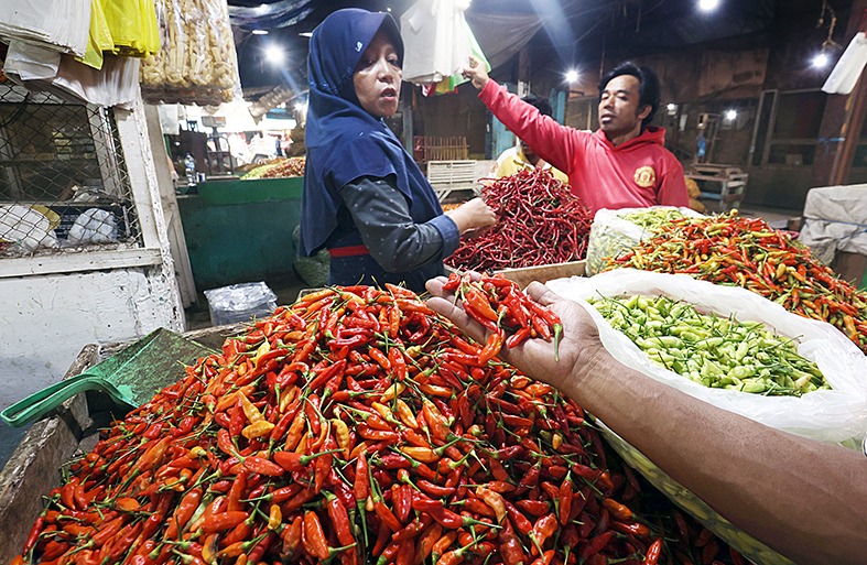 PEREKONOMIAN TERJAGA: Salah seorang penjualan cabai di Pasar Gadang, Kota Malang melayani pembeli beberapa waktu lalu.