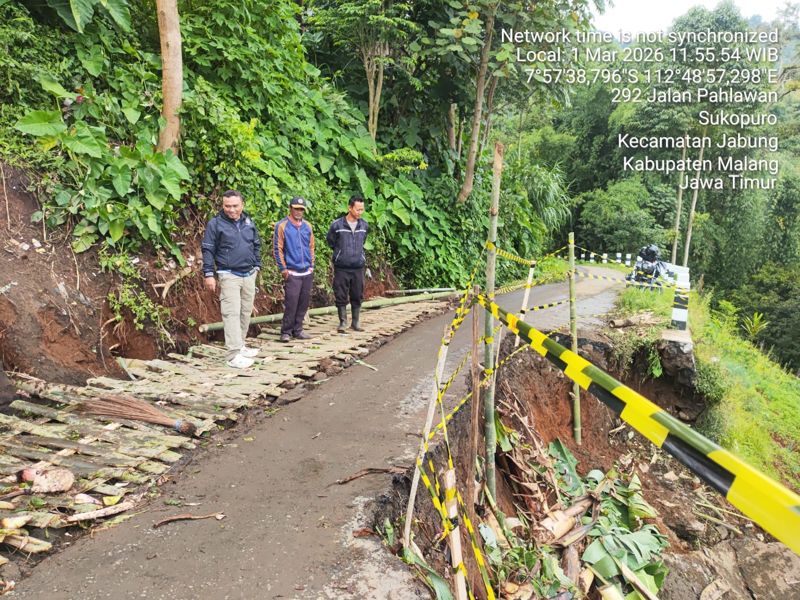 BUTUH PERBAIKAN: Personel BPBD Kabupaten Malang meninjau ruas jalan menuju Desa Taji, Kecamatan Jabung yang tergerus longsor kemarin (2/3)
