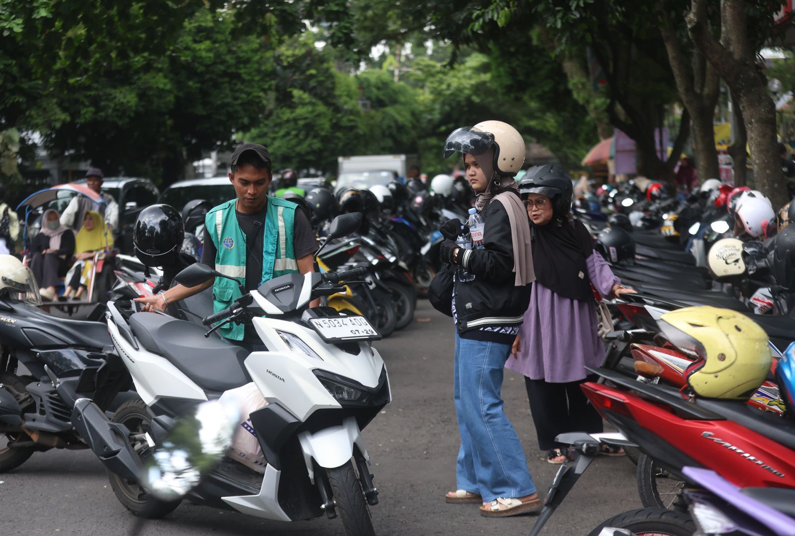 AWASI JUKIR: Seorang juru parkir membantu mengeluarkan motor pengujung Alun-Alun Merdeka Malang beberapa waktu lalu.