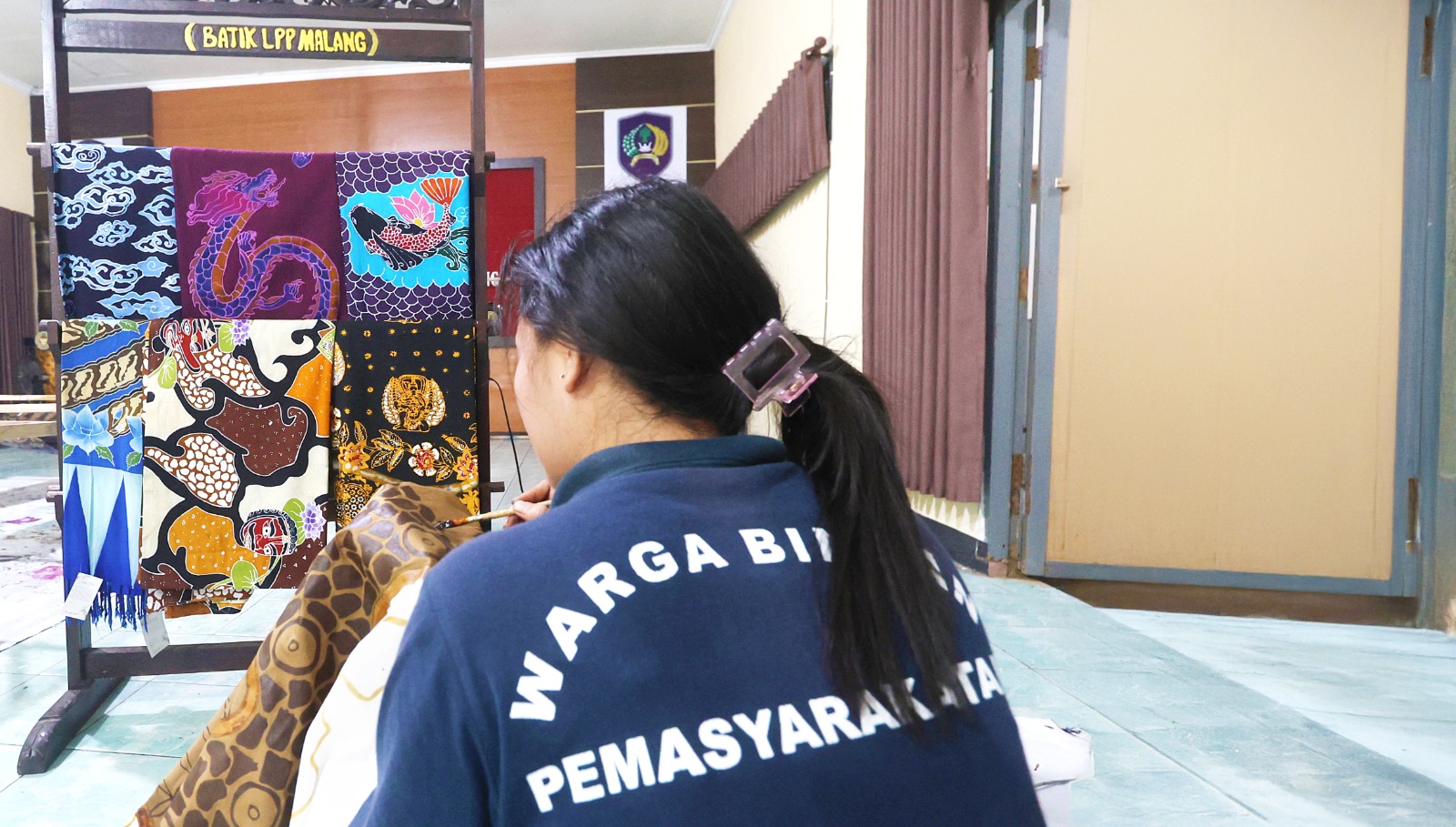 RUTIN HASILKAN PRODUK: Salah satu warga binaan LPP Kelas IIA Malang mewarnai kain batik menggunakan canting, beberapa hari lalu.