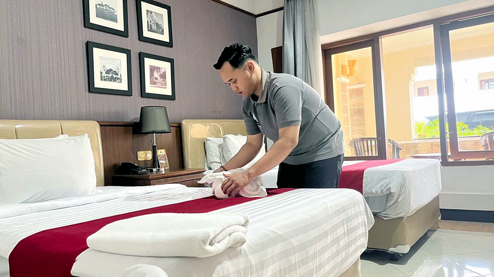 BELUM PENUHI TARGET: Salah satu housekeeper di Hotel Pelangi, Jalan Merdeka Selatan merapikan salah satu kamar, beberapa waktu lalu. (NAHDIATUL AFFANDIAH / RADAR MALANG)