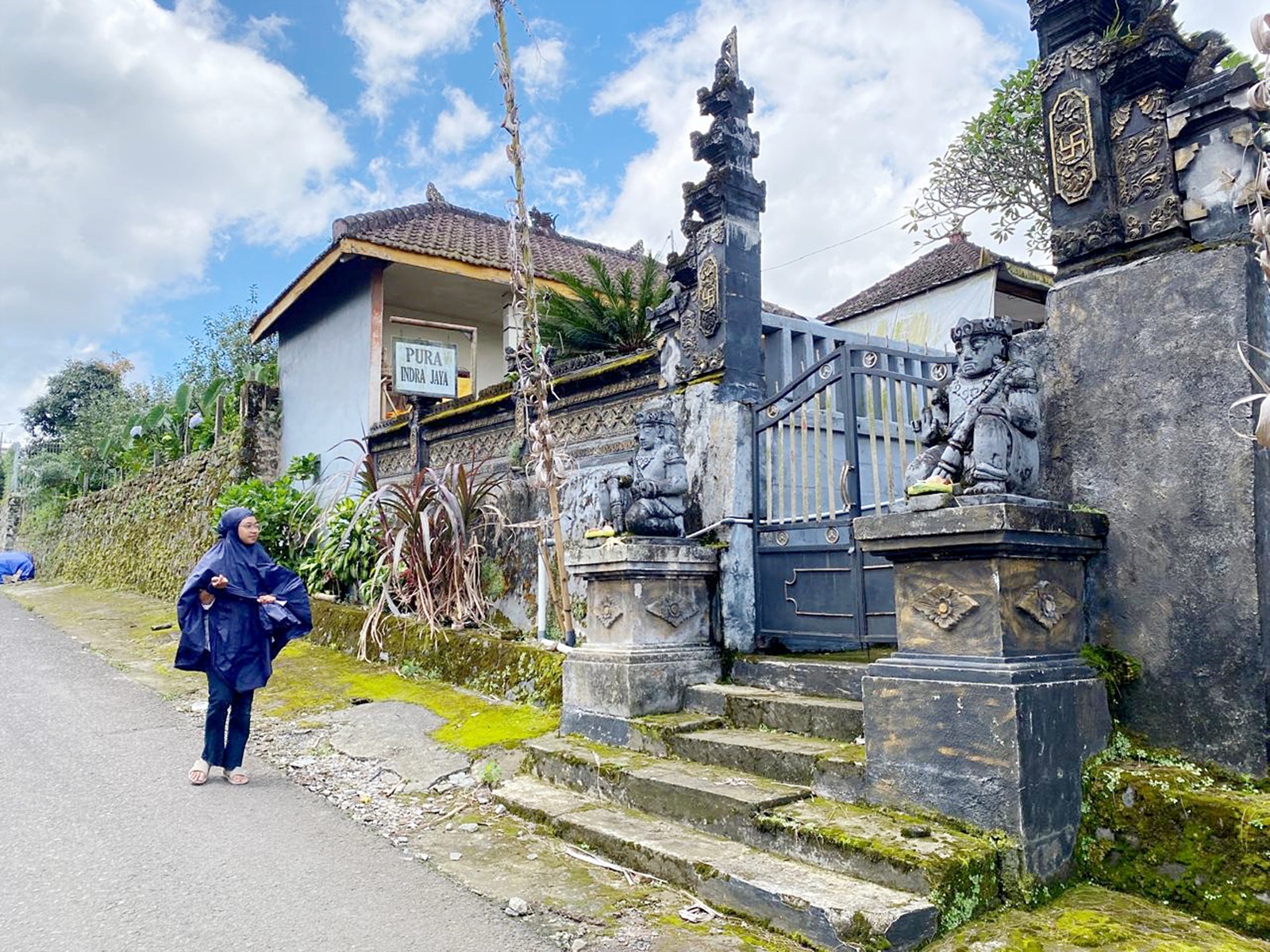 INDAHNYA KERAGAMAN: Salah satu warga Muslim yang hendak beribadah melintas di depan Pura Indra Jaya, Dusun Junggo, Desa Tulungrejo, Kecamatan Bumiaji, Kota Batu.