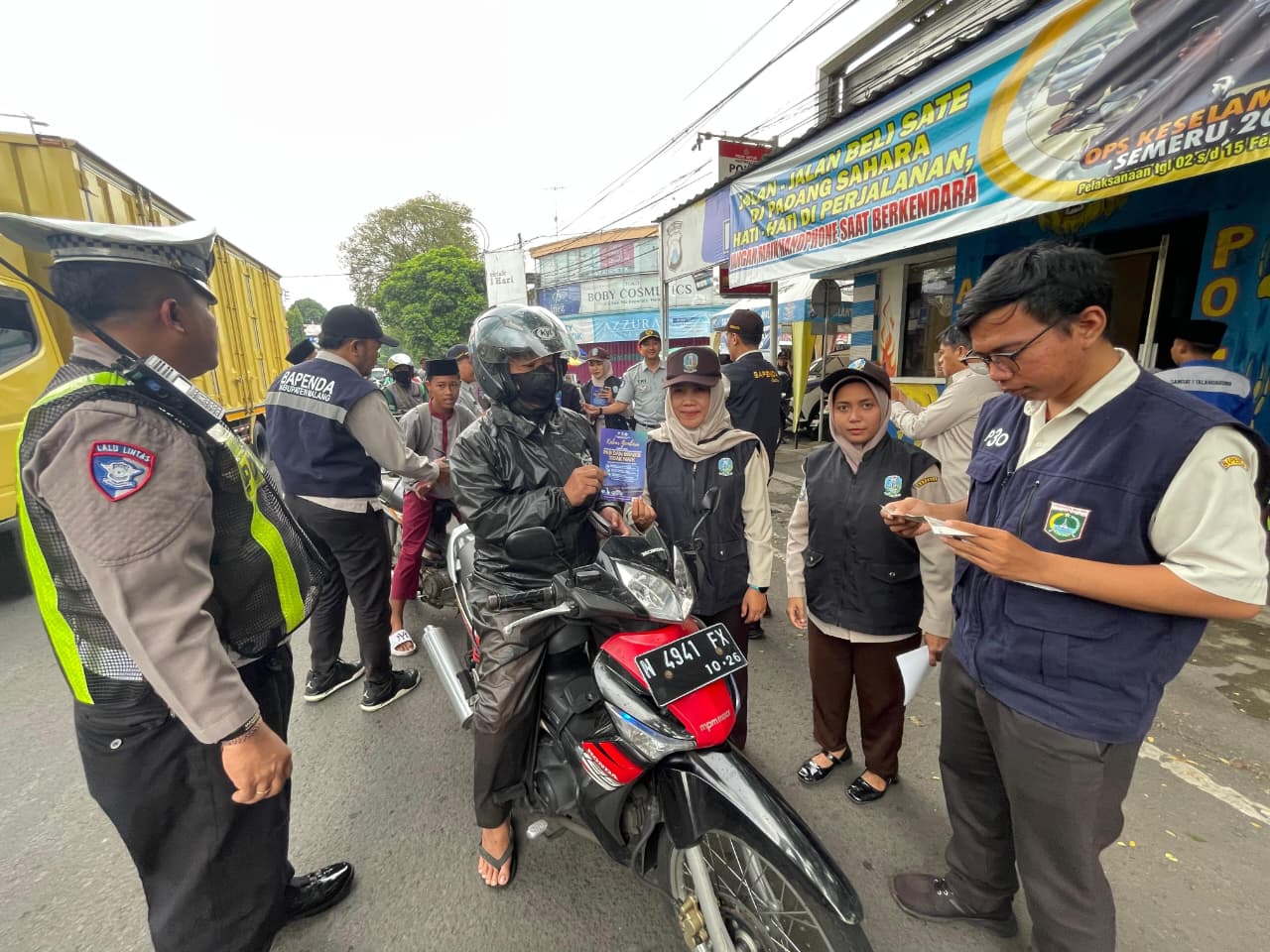 GENJOT PAJAK: Petugas memeriksa kelengkapan surat pengendara yang melintas di Jalan Ahmad Yani, depan Pasar Kepanjen.