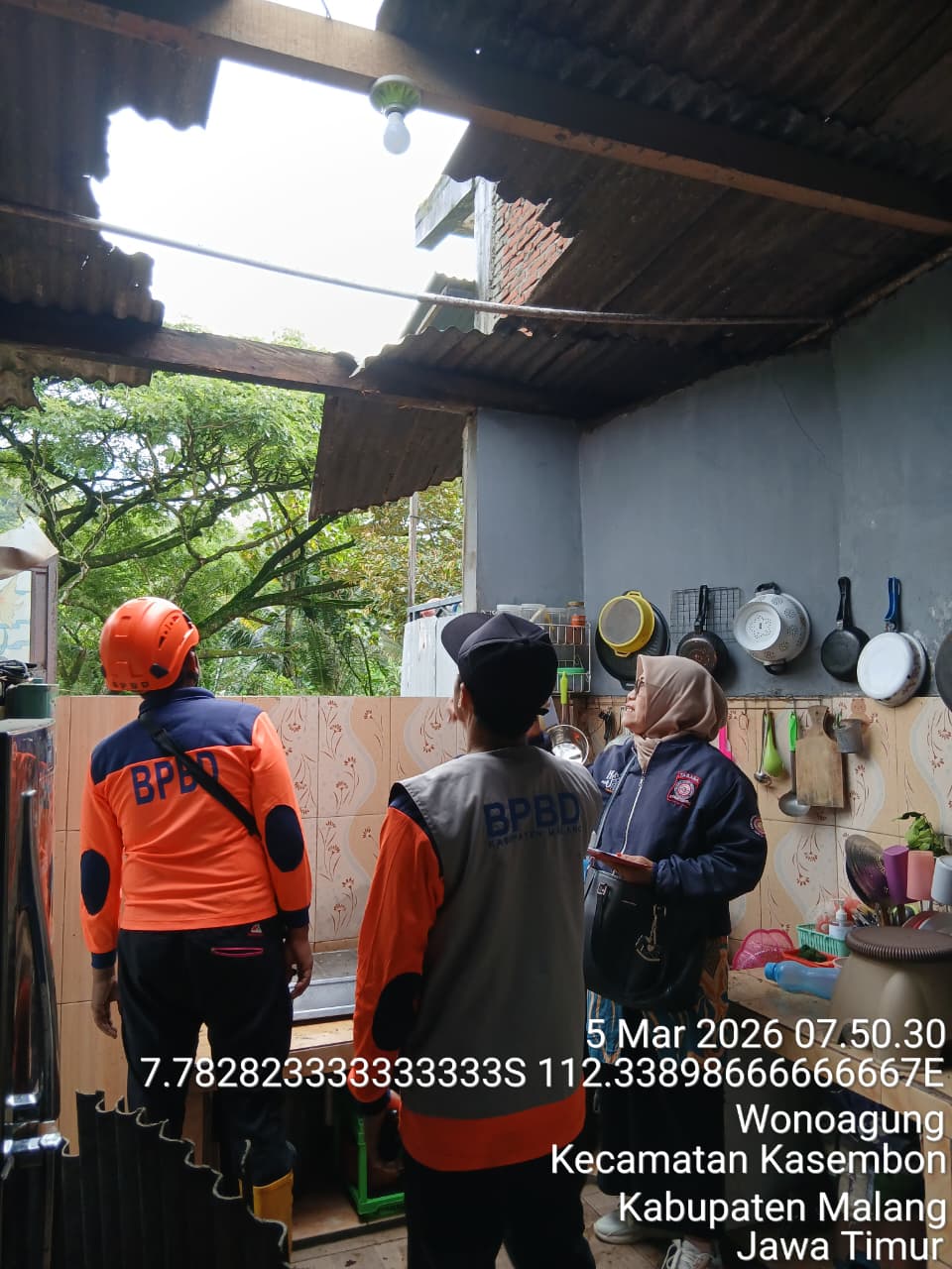 MASIH MENGANCAM: Personel BPBD Kabupaten Malang meninjau rumah warga Desa Wonoagung, Kecamatan Kasembon yang rusak akibat tersapu angin kencang kemarin.  