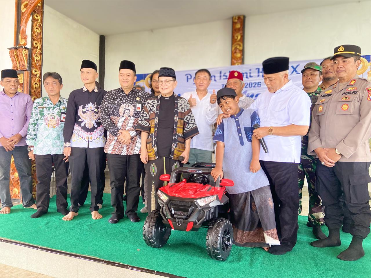 MOBIL LISTRIK: Iwan Kurniawan dan Bupati Malang HM Sanusi menyaksikan Zafier, siswa kelas 2 SD yang berhasil membawa pulang mobil listrik mainan di ajang Pekan Islami ke-XIX di Balai Desa Kucur