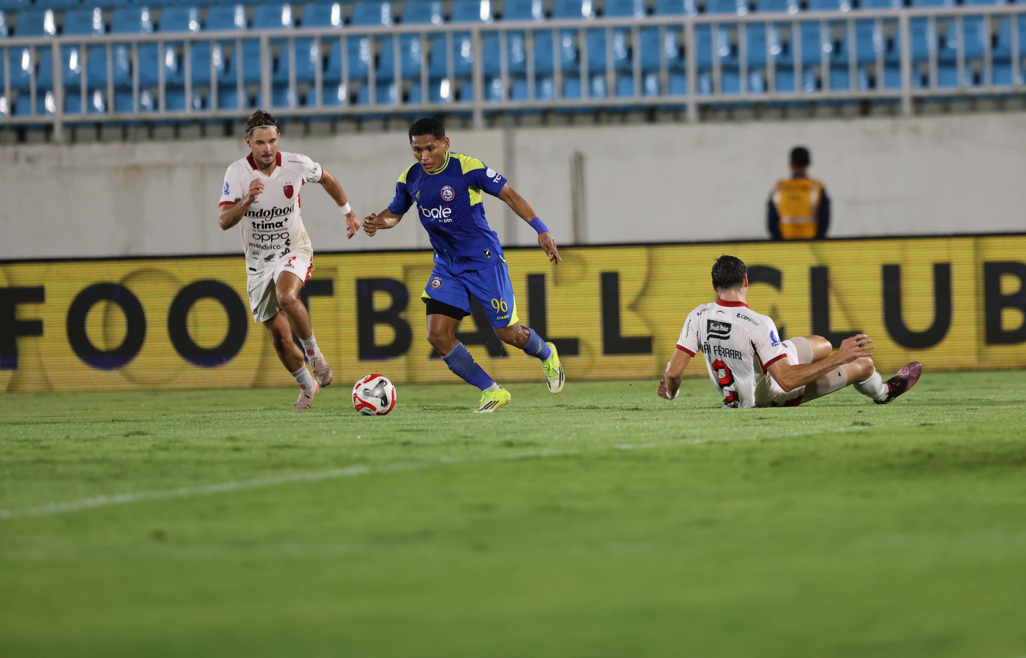 Bek kiri Arema FC Iksan Lestaluhu mengecoh pemain Bali United dalam lanjutan BRI Super League pekan ke-24 di Stadion Kanjuruhan, Jumat (6/3) malam. (Darmono/Radar Malang)
