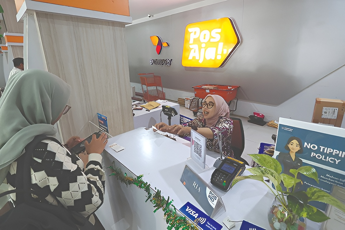 JADI OPSI PENGIRIMAN UANG: Salah satu petugas di Kantor Pos Indonesia Cabang Malang memberikan pelayanan, kemarin. (Darmono/Radar Malang)