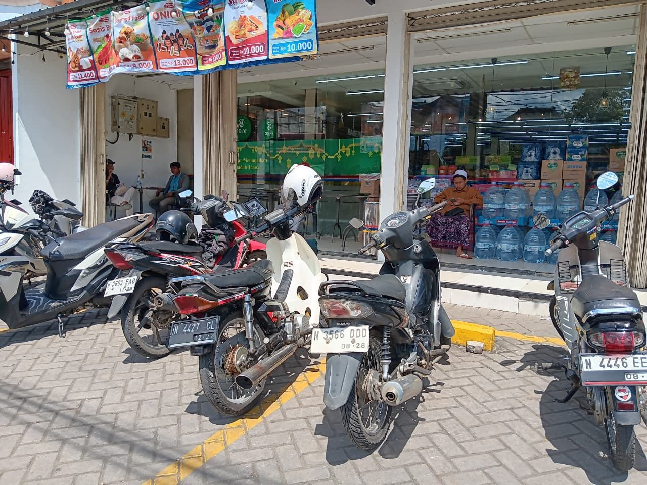 SUMBER PENDAPATAN: Motor milik pengunjung minimarket di Desa Pakisaji, Kecamatan Pakisaji diparkir berderet. Setoran pajak parkir turut menyumbang PAD. FOTO: INDAH MEI YUNITA