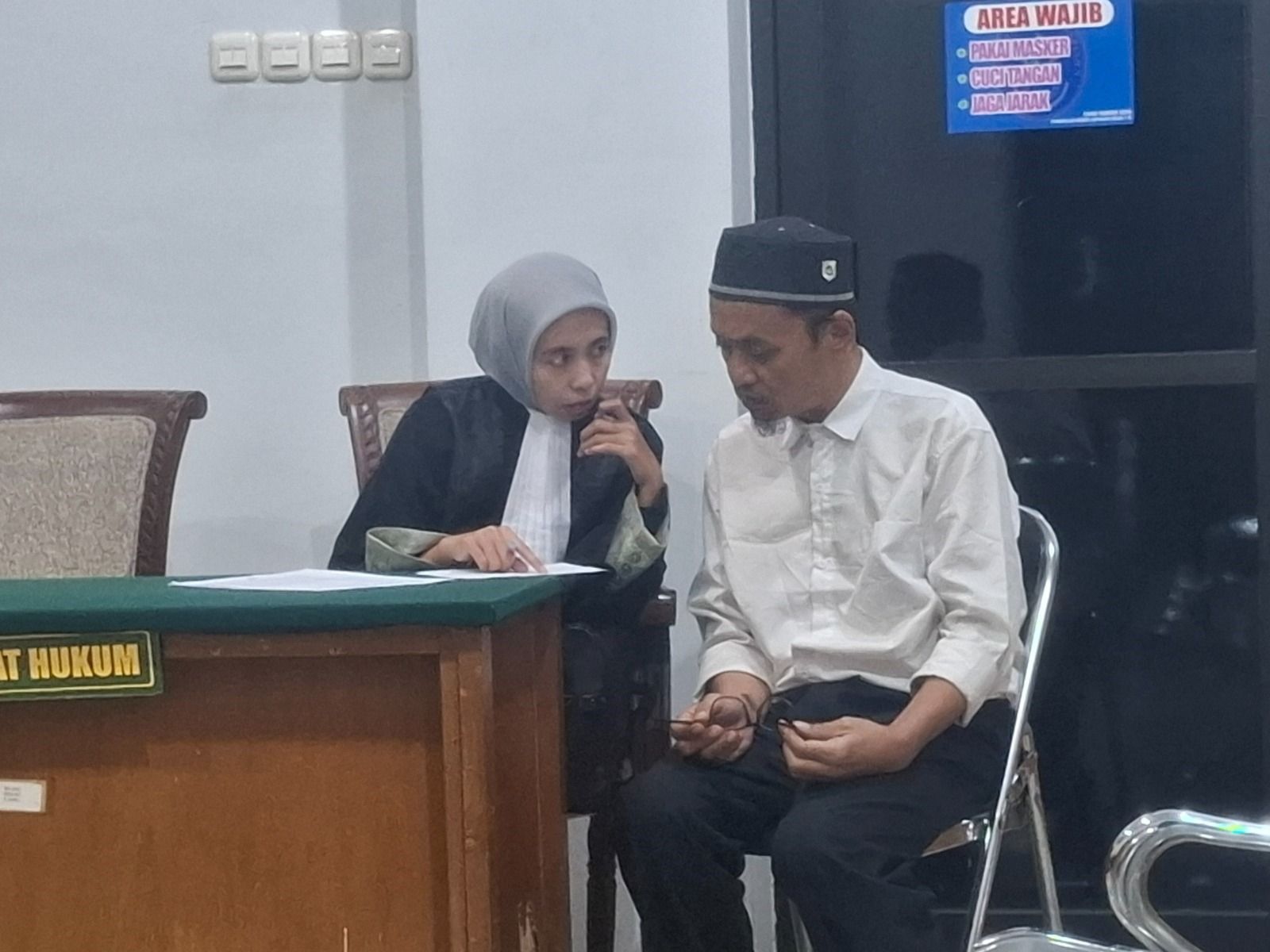 ASUSILA: Ricky Rahadimantoro Yudho, 43, berkonsultasi dengan penasihat hukumnya di ruang sidang PN Kepanjen. FOTO: BIYAN MUDZAKY HANINDITO / RADAR KANJURUHAN 