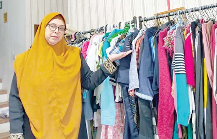 MISI SOSIAL: Anna Eva Arany berpose bersama barang dagangan di rumahnya beberapa waktu lalu. HIDAYATI / FREELANCE RADAR MALANG