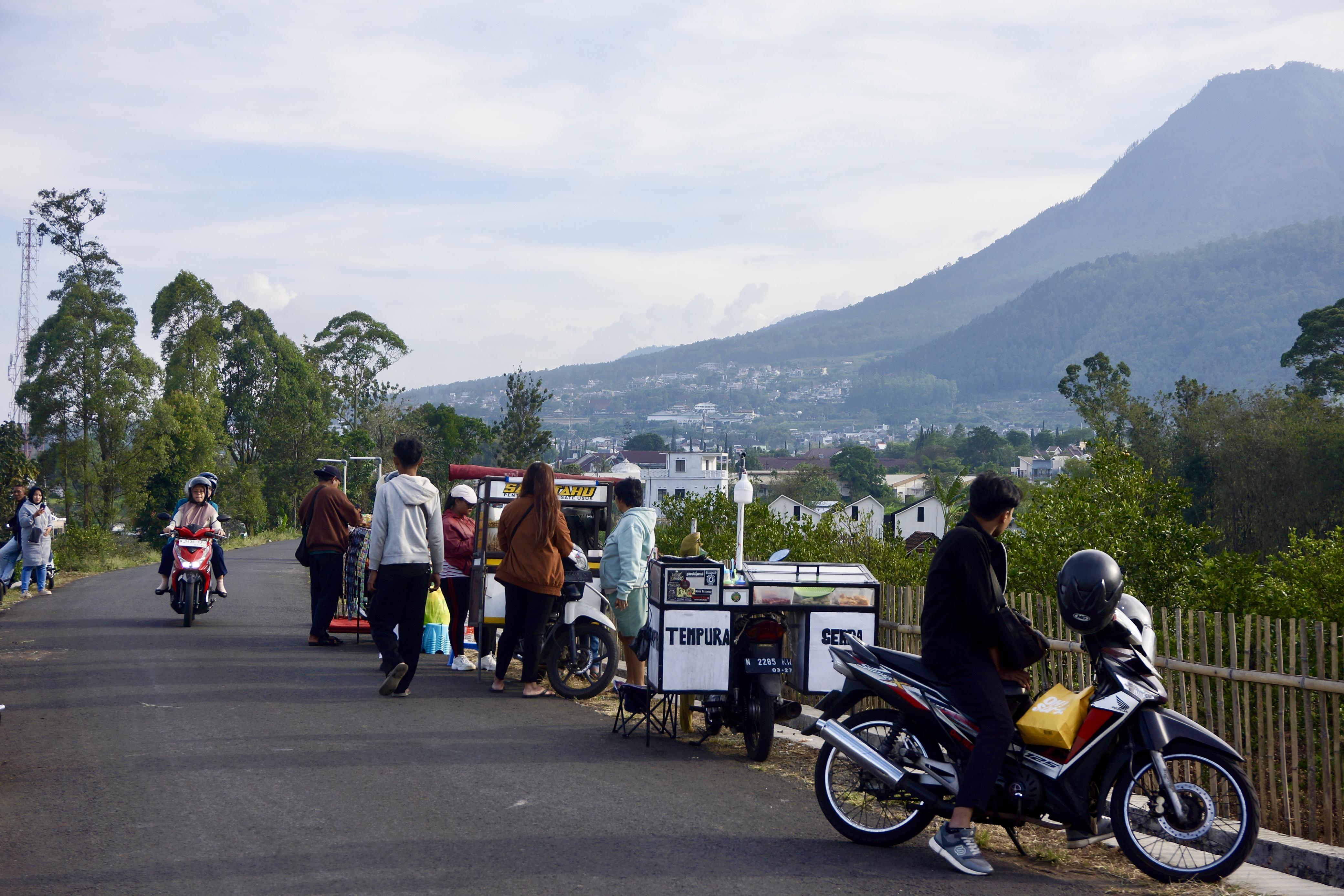 JADI JUJUGAN: Warga Kota Batu datang ke Puthuk Tritih jelang berbuka puasa kemarin sore. Mereka menghabiskan waktu dengan menikmati pemandangan Gunung Panderman.