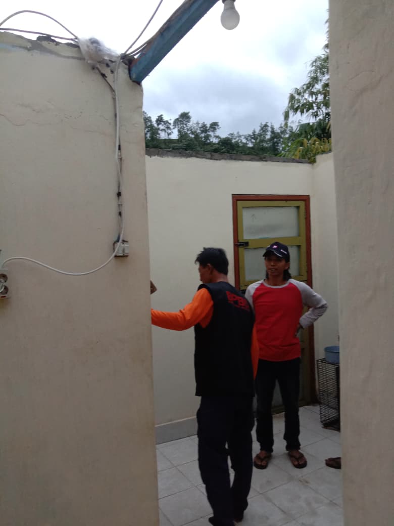 Personel BPBD Kabupaten Malang mengecek kondisi rumah warga di Ngantang yang rusak karena angin kencang. (BPBD Kabupaten Malang)