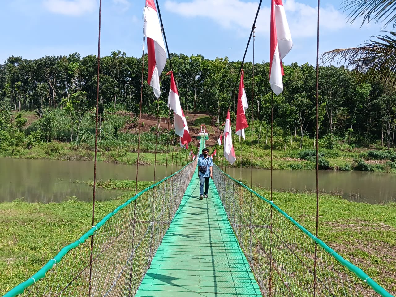 Warga melintasi Jembatan Garuda di Desa Tenyang, Kecamatan Sumberpucung, Selasa (10/3). (Indah Mei Yunita/Radar Malang)