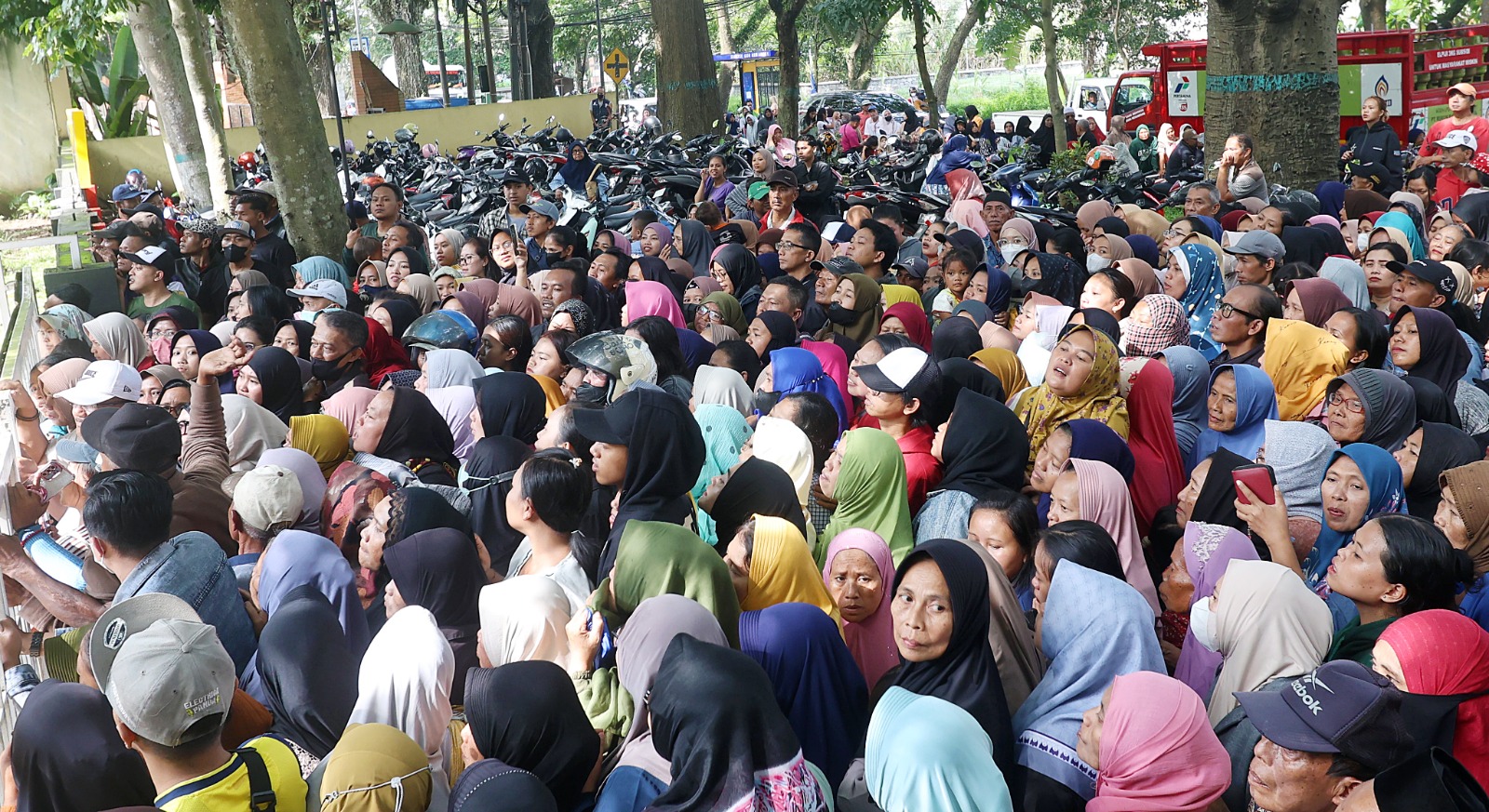 MEMBELUDAK: Sejumlah warga berdesakan di depan Kantor Kecamatan Kedungkandang, di Jalan Mayjen Sungkono, Kelurahan Buring, kemarin. Warga datang sejak pagi untuk mengikuti program pasar murah.