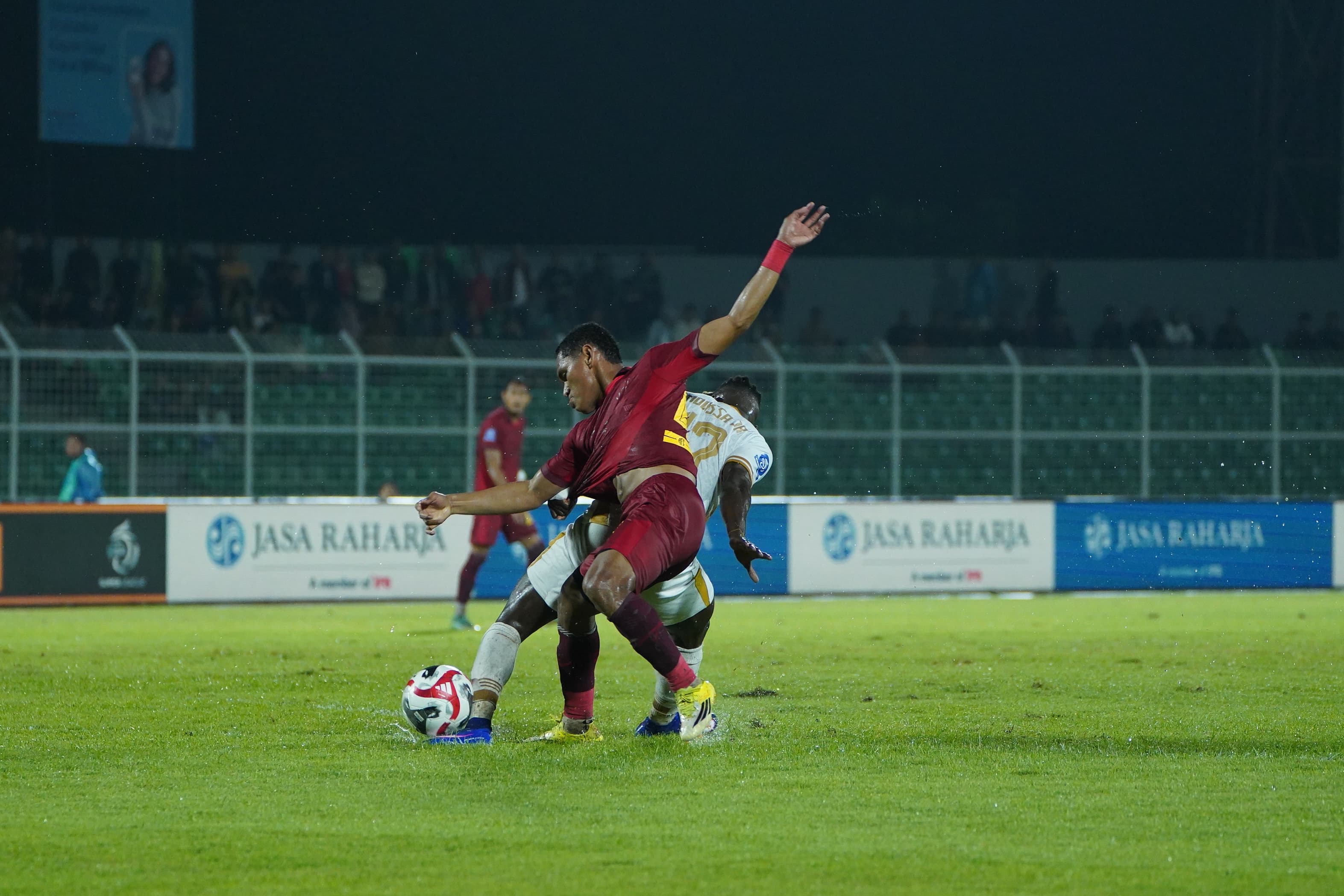Bek kiri Arema FC Iksan Lestaluhu berduel dengan pemain Bhayangkara FC Moussa Sidibe, Selasa (10/3) malam. (MO Arema FC)