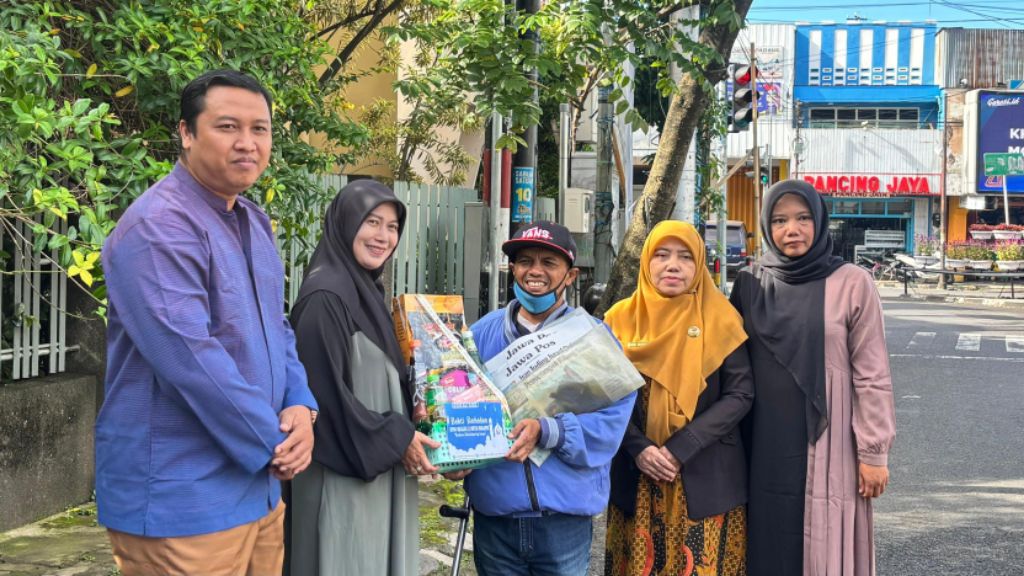 PEDULI: Manajemen SMAN 2 Malang berbagi kebahagiaan dengan loper koran Jawa Pos Radar Malang.