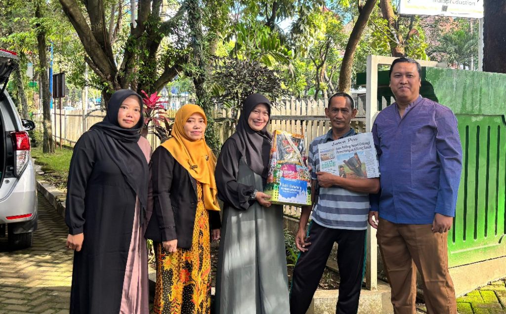 PELOPOR: Kepala SMAN 2 Malang Eny Retno Diwati MPd (tengah) memberikan parcel lebaran kepada loper difabel Jawa Pos Radar Malang.