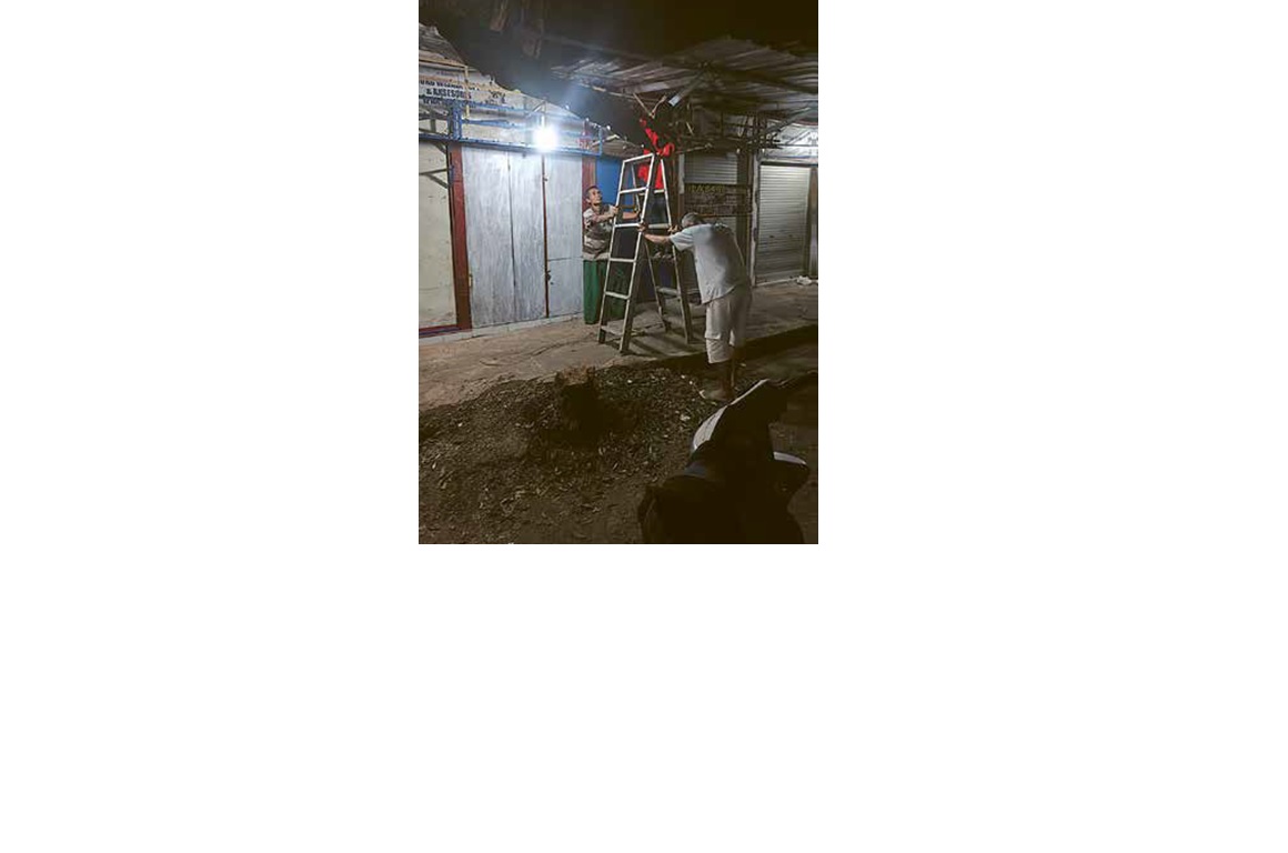 SWADAYA: Beberapa pedagang di Terminal Tumpang memperbaiki kios yang porak-poranda akibat terpaan angin kencang beberapa waktu lalu.