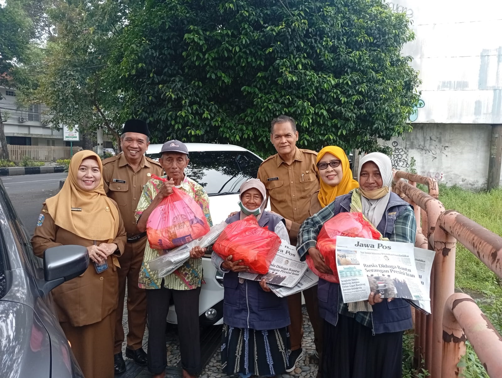 BERI SEMANGAT: Kepala Cabdindik Kabupaten Malang Dwi Anggraeni SPd MPd bersama Ketua MKKS SMA dan SMK Negeri Kabupaten Malang memberikan motivasi dan berbagi parcel kepada loper koran yang sudah