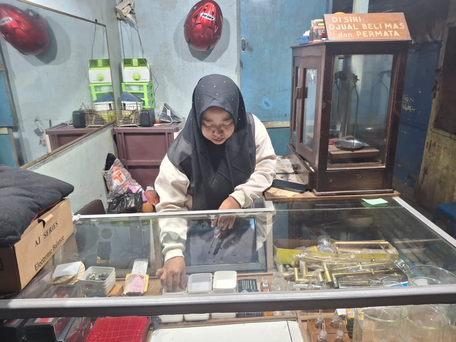 ALAMI NASIB NAHAS: Anak pemilik Toko Perhiasan Banyumas Mariah Luthfiyah memegang perhiasan yang dijual di tokonya.