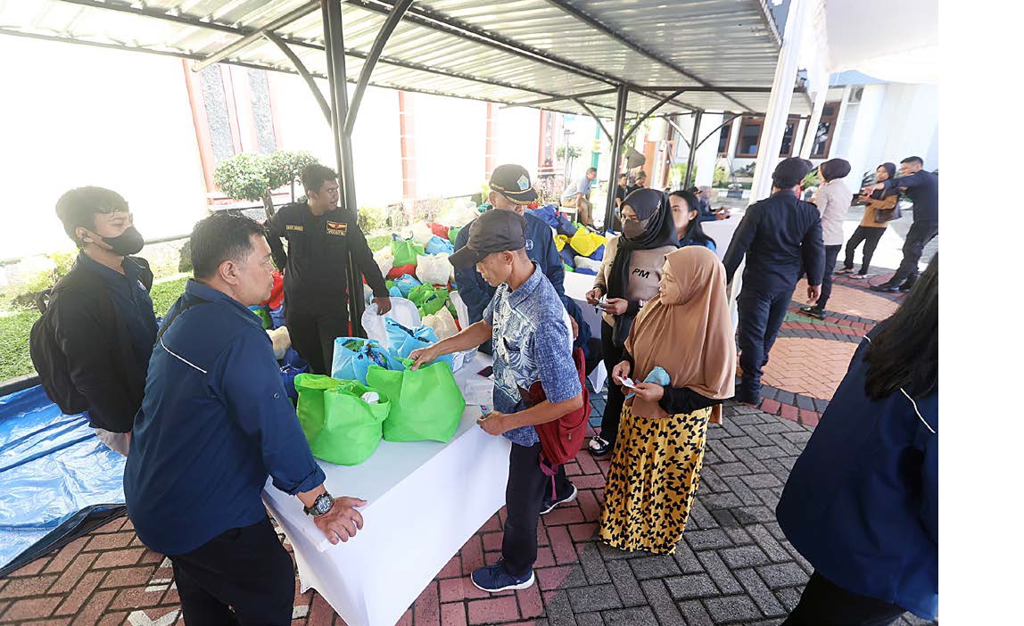 LEBIH TERATUR: Sejumlah warga mengantre untuk menebus paket bahan pokok murah yang dijual senilai Rp 50 ribu di Kantor Kejari Kota Malang, kemarin. Kegiatan kemarin menjadi yang ketiga kalinya digelar