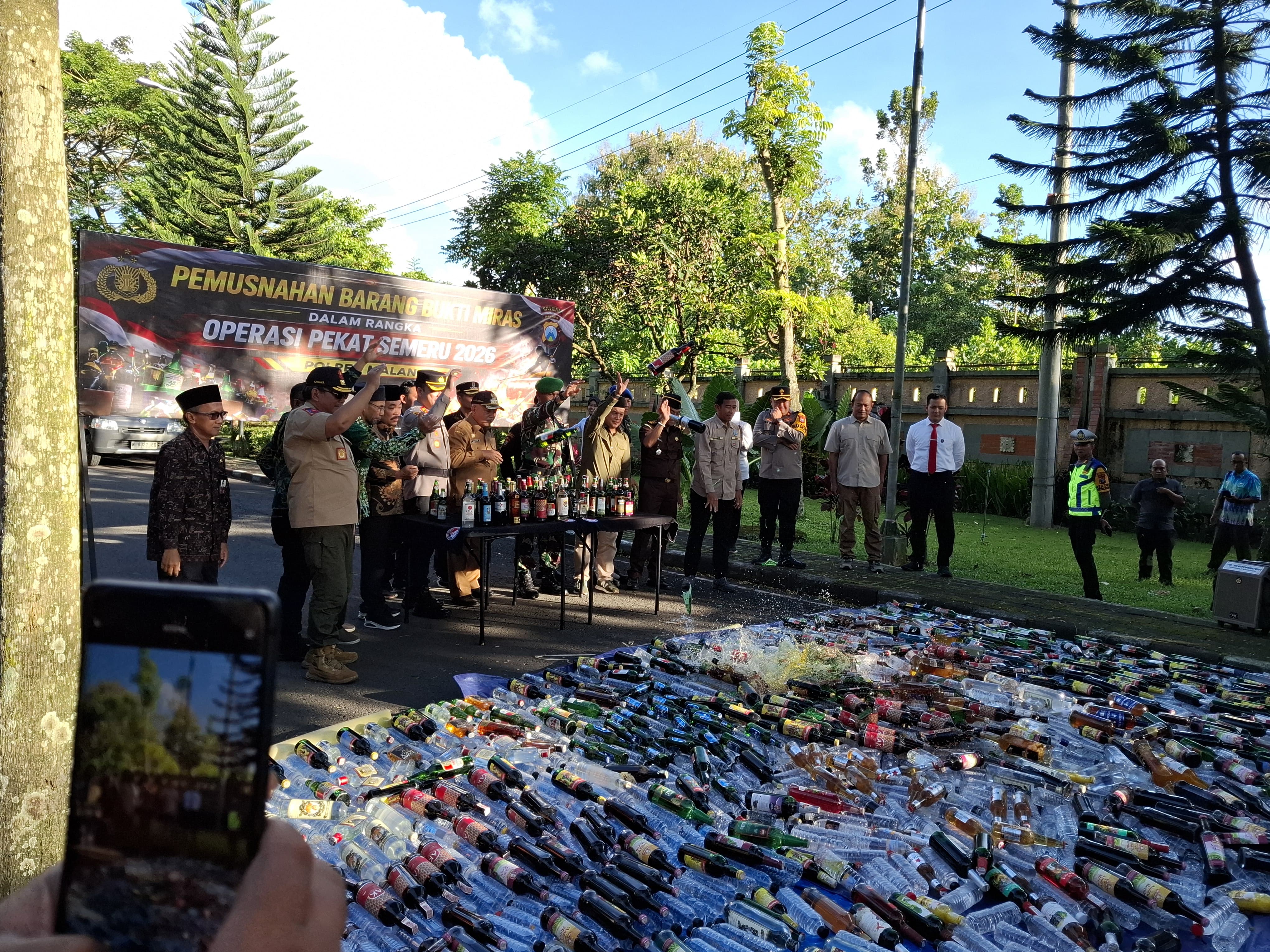 Polres Malang memusnahkan botol miras hasil sitaan selama Operasi Pekat Semeru kemarin (12/3). (Biyan Mudzaky Hanindito/Radar Malang)