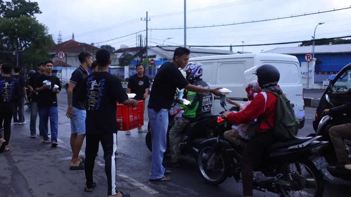BAGI TAKJIL: Para pemain Unggul FC Malang membagikan takjil berbuka kepada para pengendara yang melintas di Unggul Sports Center, Minggu lalu (15/3).