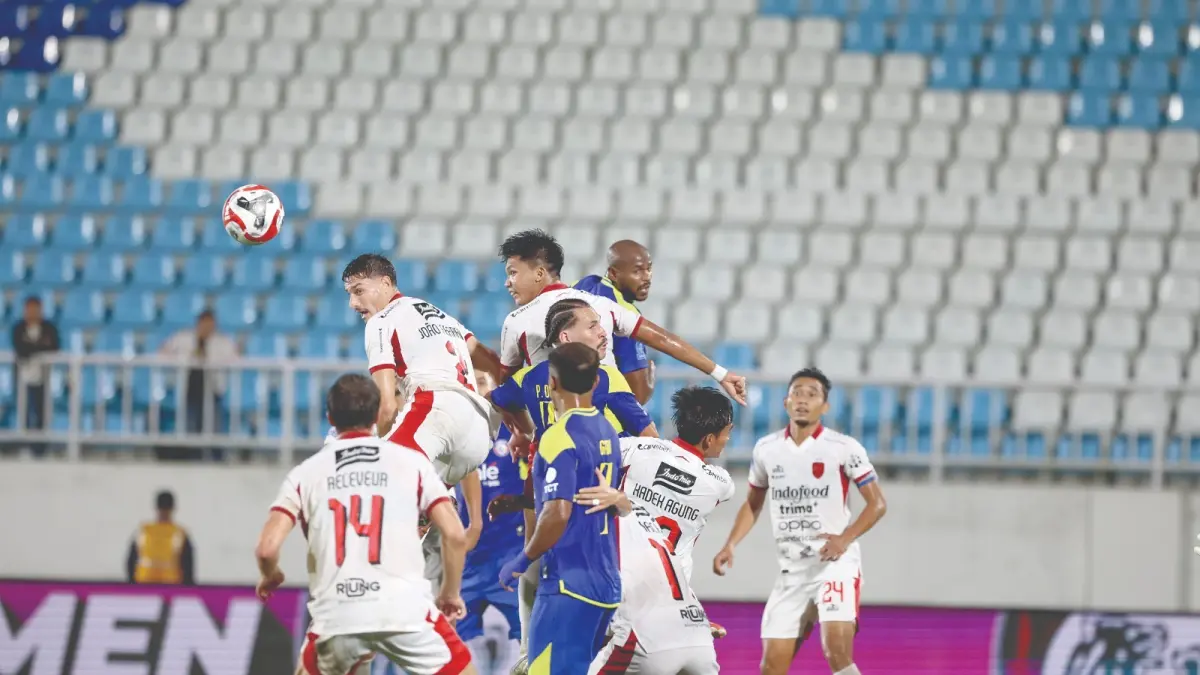 SIAP BERBENAH: Para pemain Arema FC melakukan duel udara dalam laga BRI Super League melawan Bali United di Stadion Kanjuruhan.