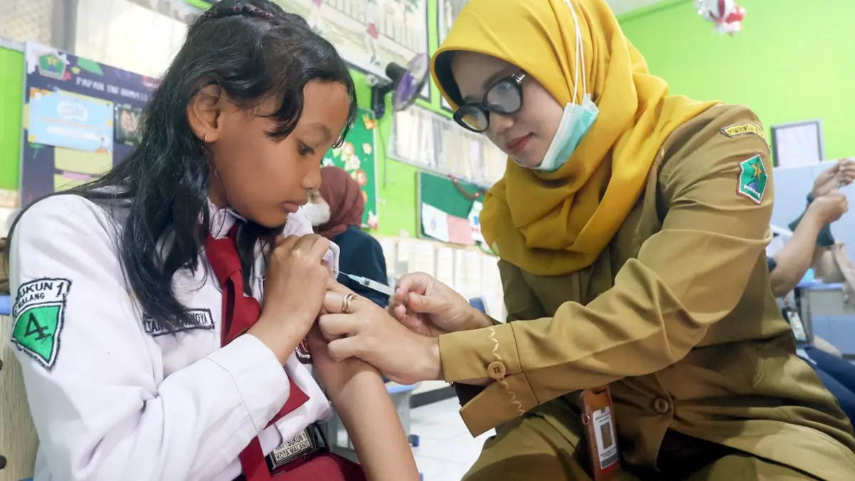 VAKSINASI: Tenaga kesehatan puskesmas
menyuntikkan vaksin ke siswa SDN Sukun
1 beberapa waktu lalu.