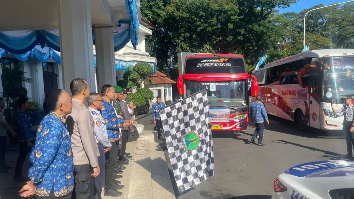 Wali Kota Malang Wahyu Hidayat (pegang bendera) memberangkatkan pemudik di halaman Balai Kota Malang, Selasa (17/3). (Andika Satria Perdana/Radar Malang)