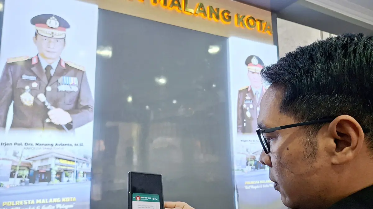 HARUS WASPADA: Kasi Humas Polresta Malang Kota Ipda Lukman Sobikhin menunjukkan modus penipuan menggunakan file APK yang dikirim lewat WhatsApp (WA), Selasa lalu (17/3). (Nabila Amelia / Radar Malang)