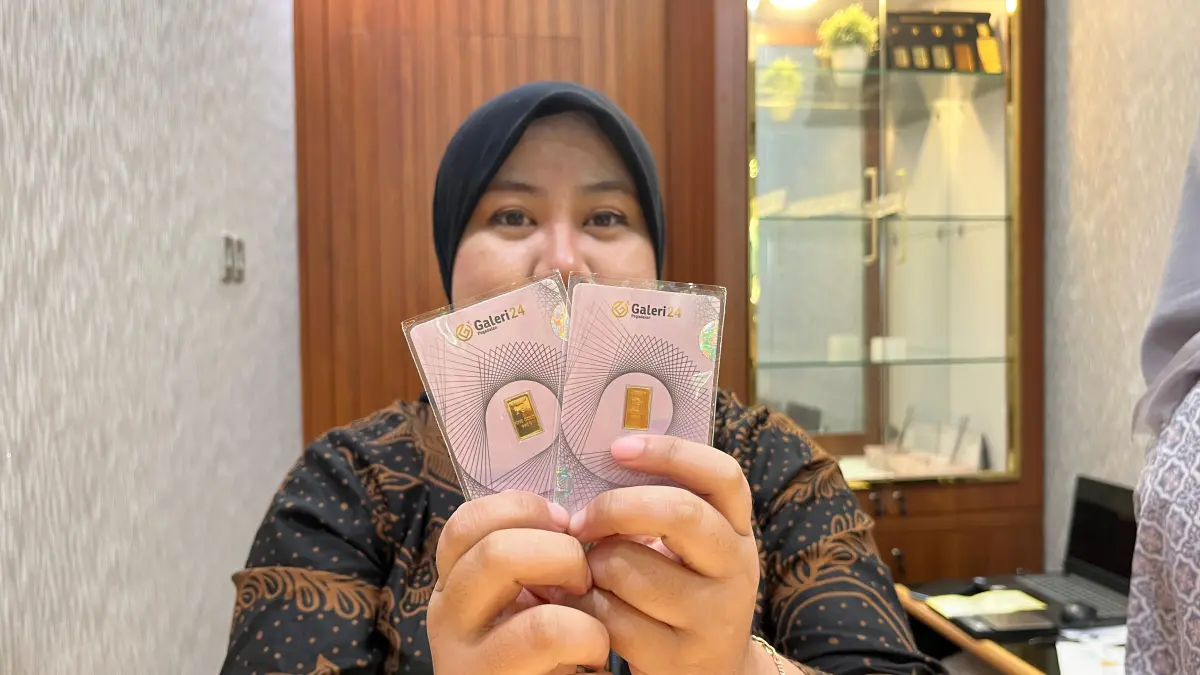Penjaga toko emas memamerkan logam mulia Galeri24 kepada konsumen. (Nahdiatul Affandiah/Radar Malang)