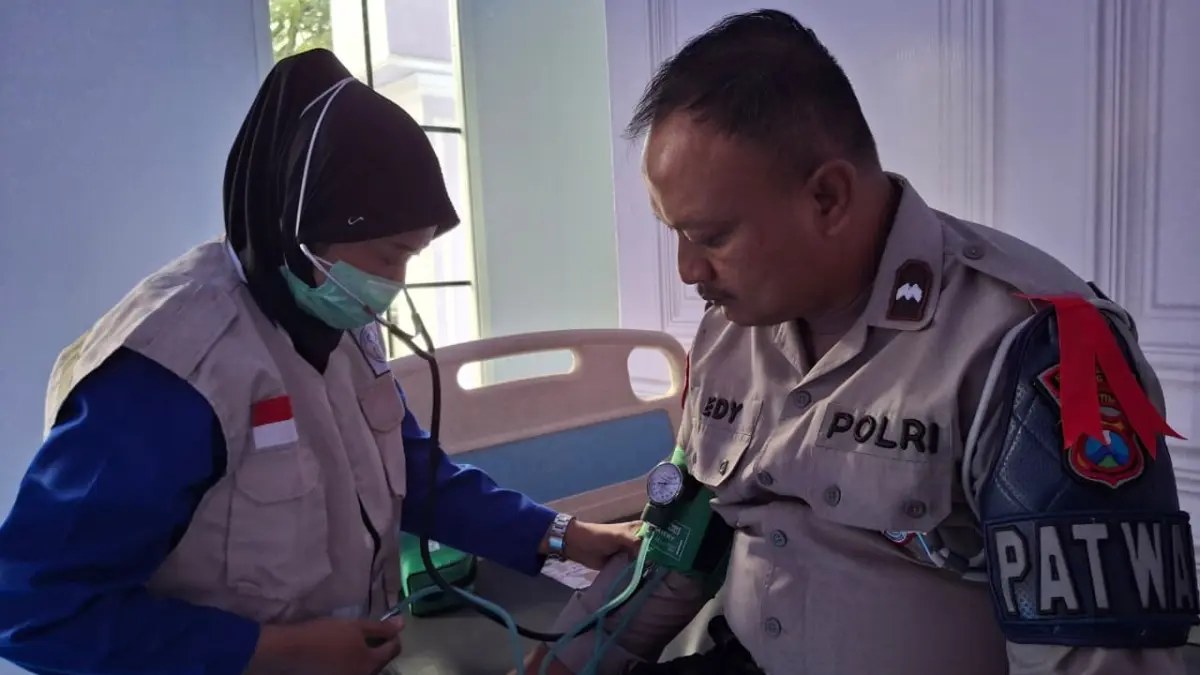 MANFAATKAN LAYANAN: Salah satu personel kepolisian melakukan cek kesehatan di Posyan Stasiun untuk memastikan kondisinya tetap prima, kemarin (19/3).(Nabila Amelia / Radar Malang)