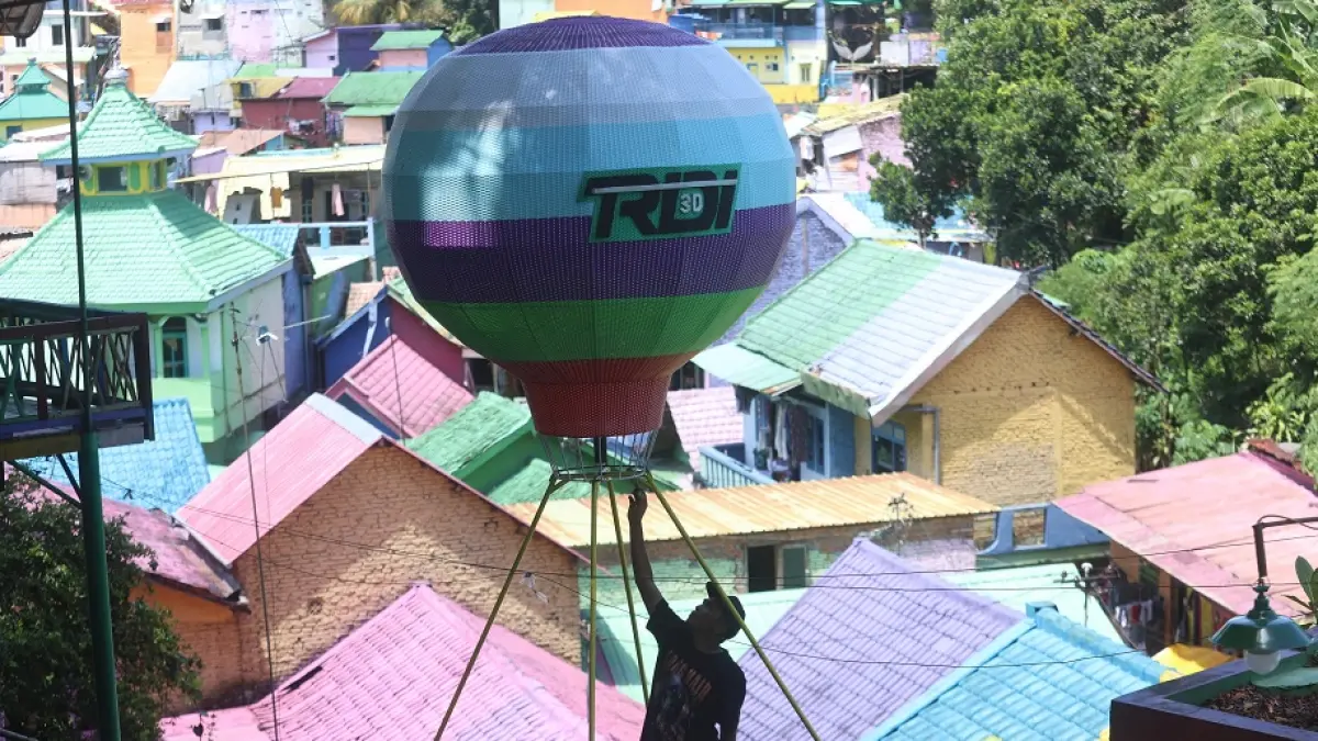 SIAP SAMBUT WISATAWAN: Pengelola Wisata Kampung Tridi (3D) menyiapkan replika balon udara sebagai spot foto yang terbaru. (DARMONO / RADAR MALANG)
