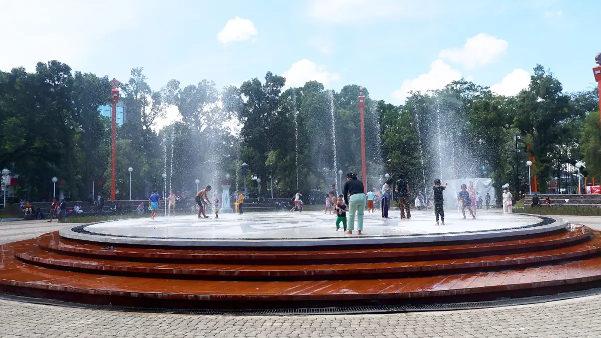 SIAPKAN SKEMA PENGAWASAN: Sejumlah warga bermain di wahana air mancur Alun-Alun Merdeka, kemarin. Satpol PP Kota Malang memastikan area dalam alun-alun bakal steril dari PKL selama libur Lebaran. (Darmono / Radar Malang)
