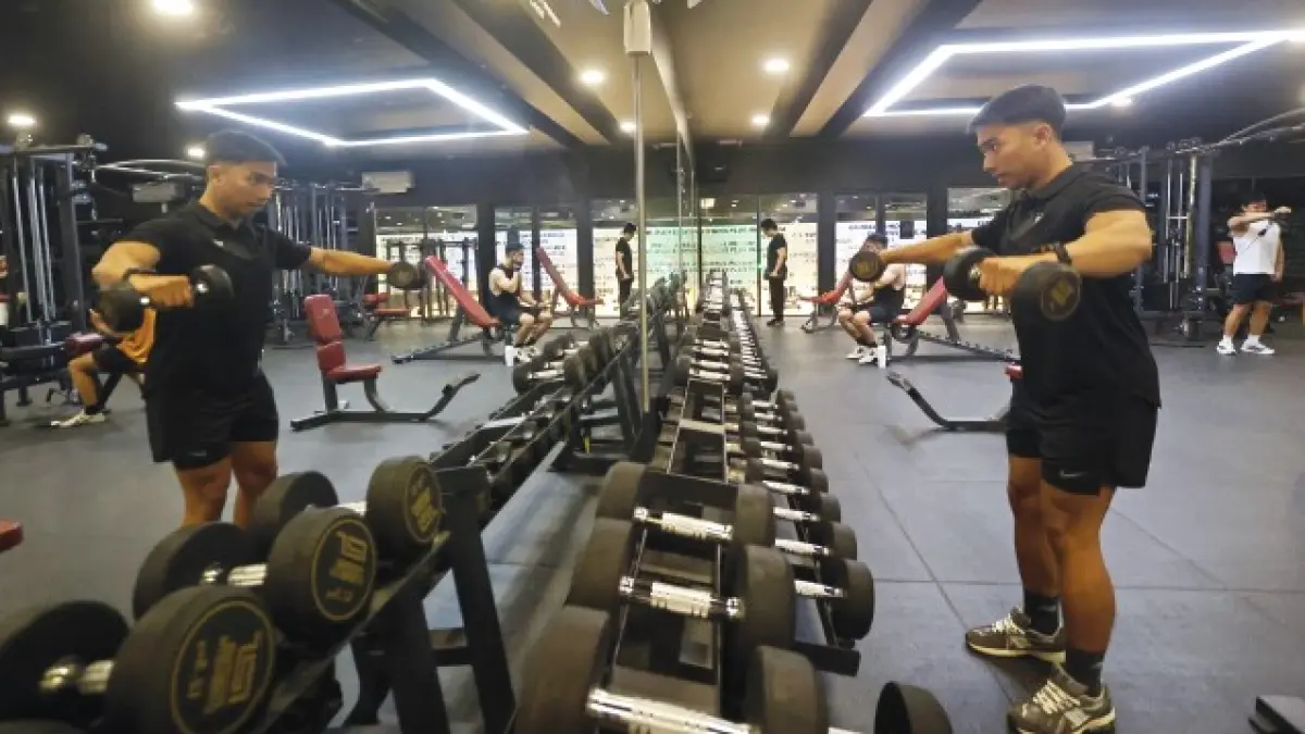 BENTUK MASSA OTOT: Member Fitness Plus Sawojajar mengangkat beban dengan memakai barbel beberapa waktu lalu.